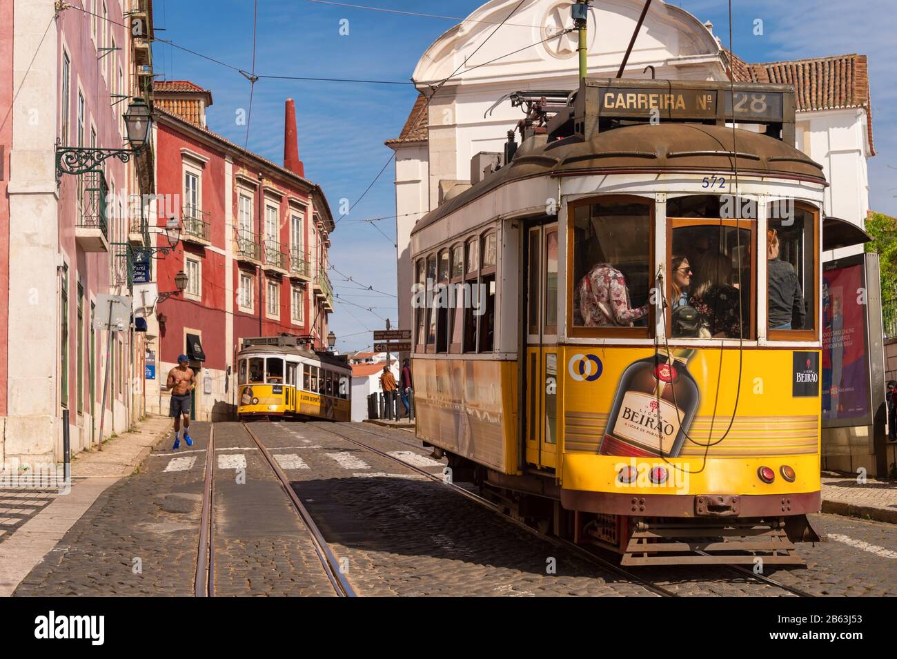 Lisbonne, Portugal - 8 mars 2020: Les touristes qui voyagent le célèbre tramway jaune 28 dans le quartier d'Alfama Banque D'Images