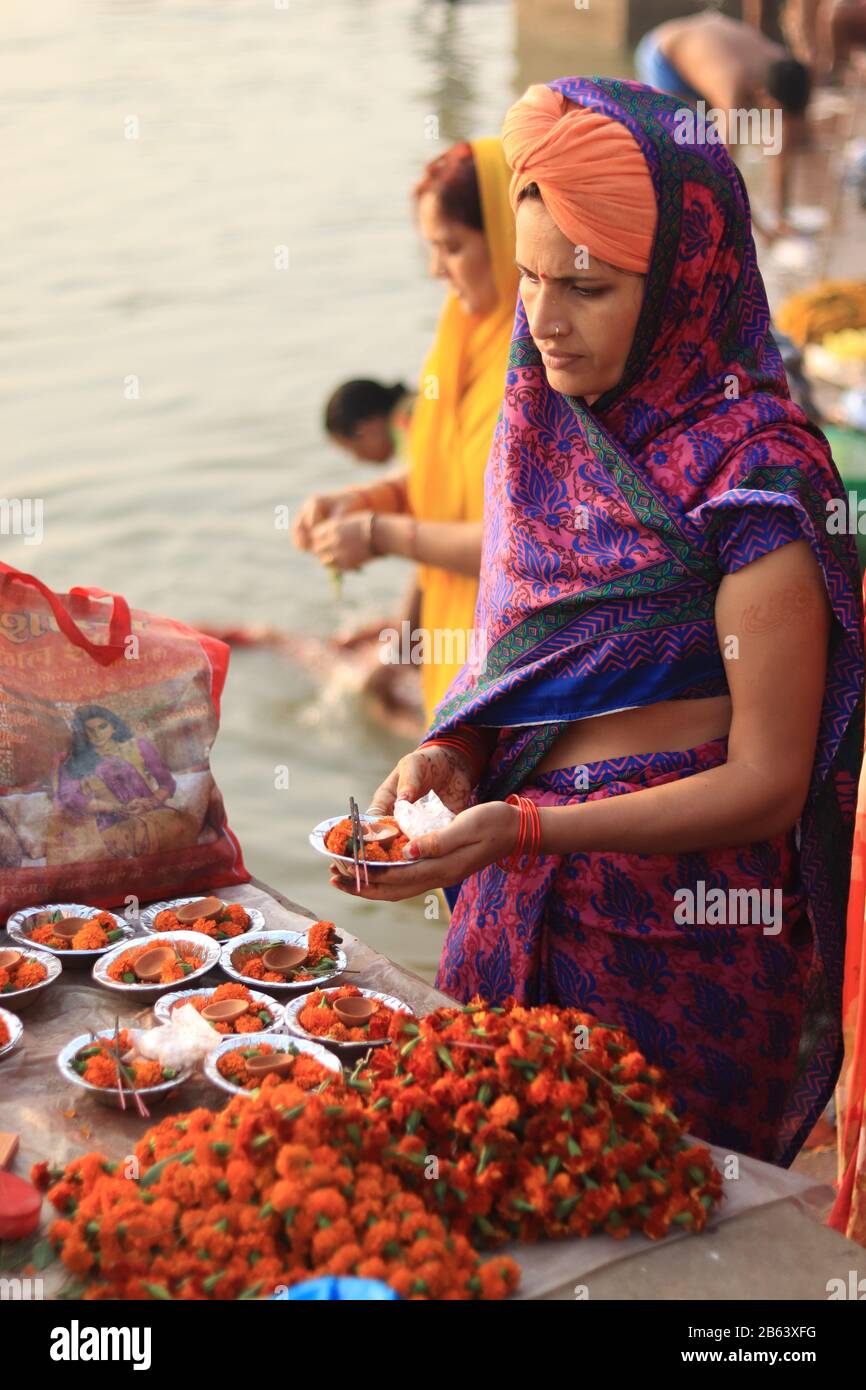 Une femme achète des fleurs pour le Saint Ganga River Banque D'Images