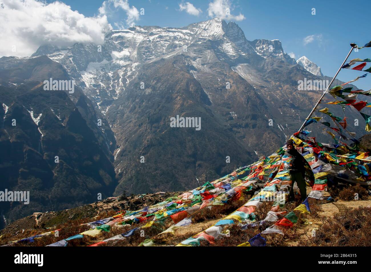 Trekker debout dans des drapeaux de prière au Népal région de l'Everest Banque D'Images Trekker debout dans des drapeaux de prière au Népal région de l'Everest Banque D'Images