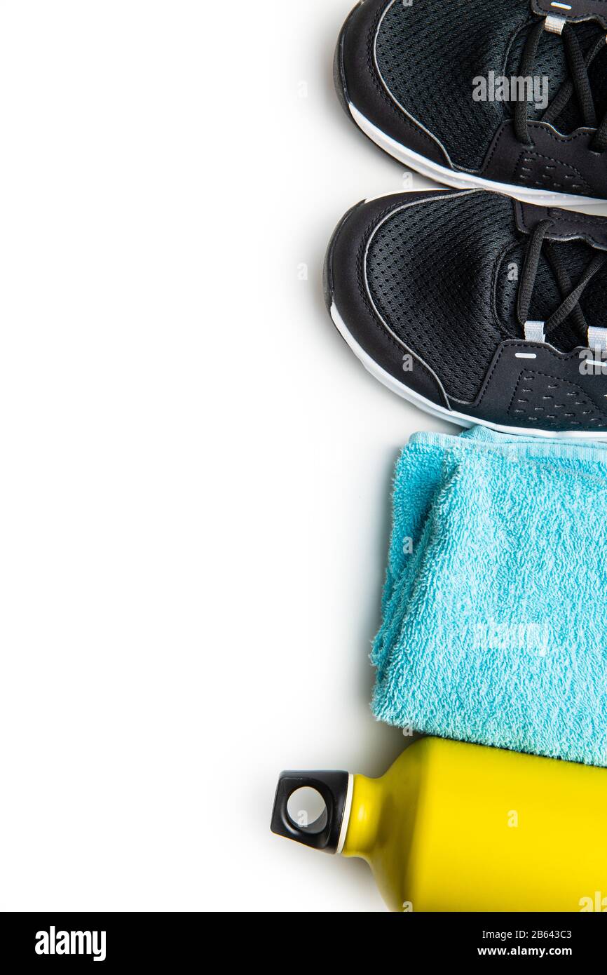 Concept de forme physique. Chaussures de sport noires, serviette et bouteille isolées sur fond blanc. Banque D'Images