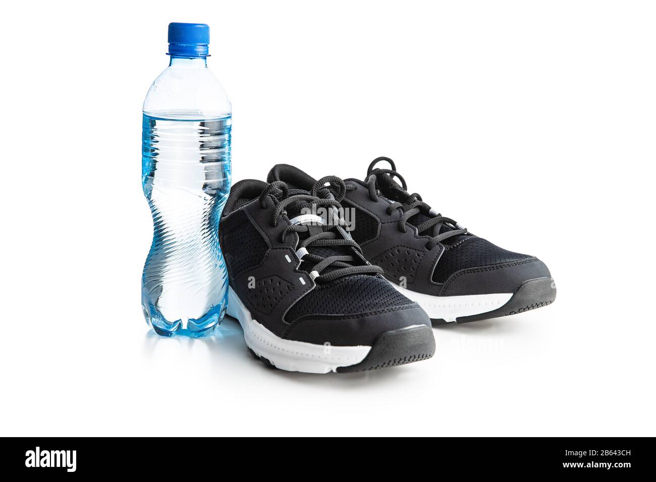 Chaussures de sport noires et bouteille d'eau isolée sur fond blanc. Banque D'Images