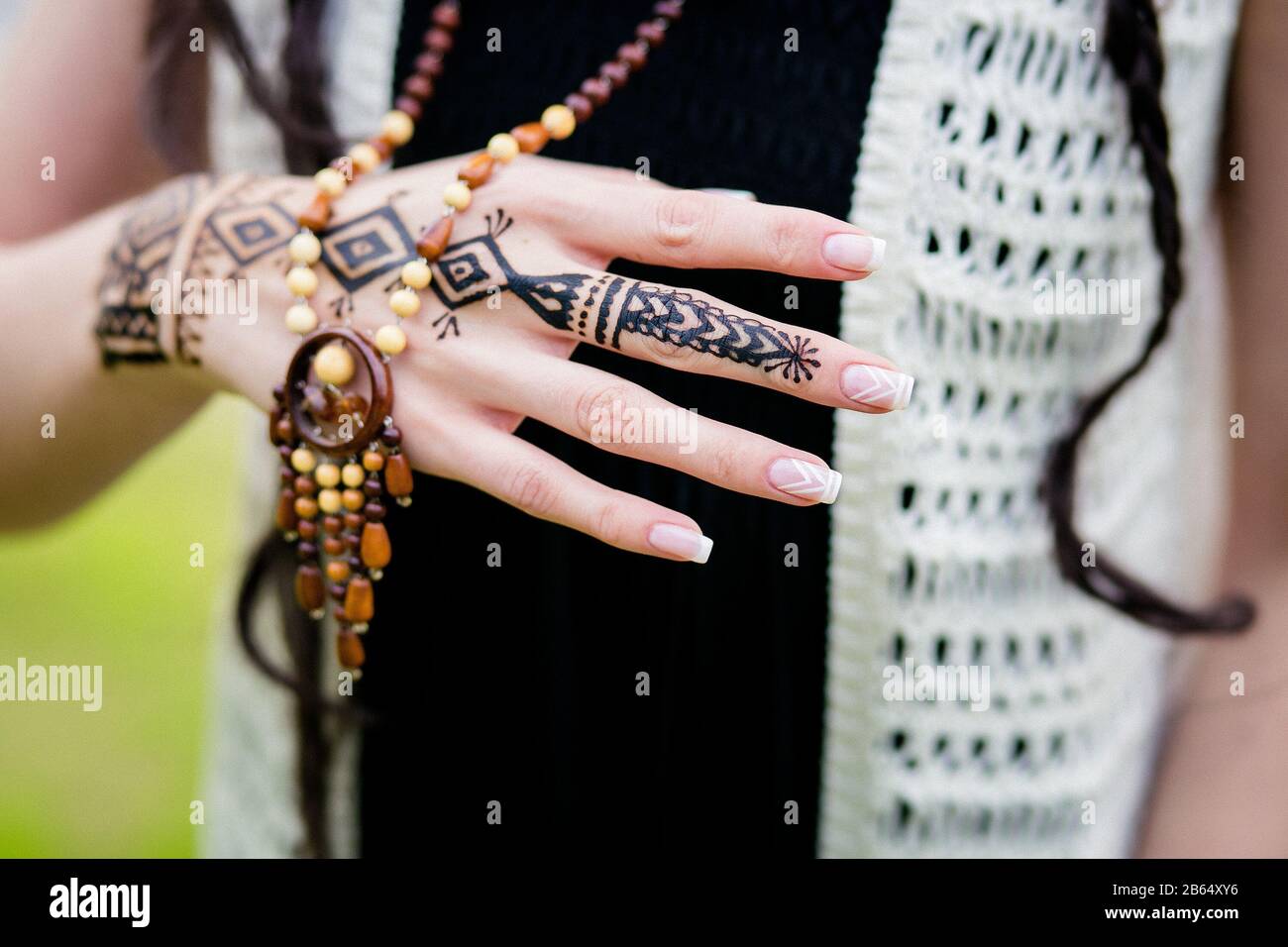 Gros plan photo des mains des femmes avec henna tattoo mehndi sur la robe bleu vif, assis femme dans le style boho, la photographie de style de beauté Banque D'Images
