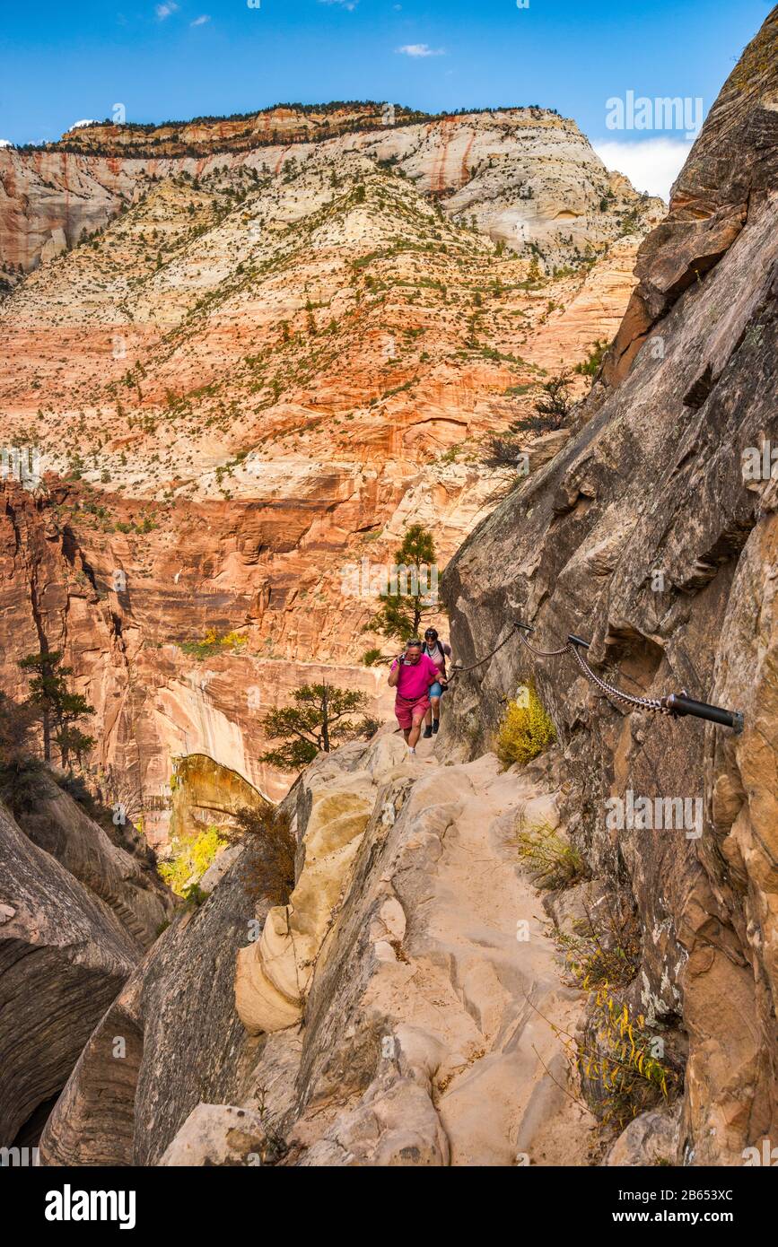 Randonneurs à Hidden Canyon Trail, canyon suspendu au-dessus de Zion Canyon, Temple de Sinawava à distance, Zion National Park, Utah, États-Unis Banque D'Images