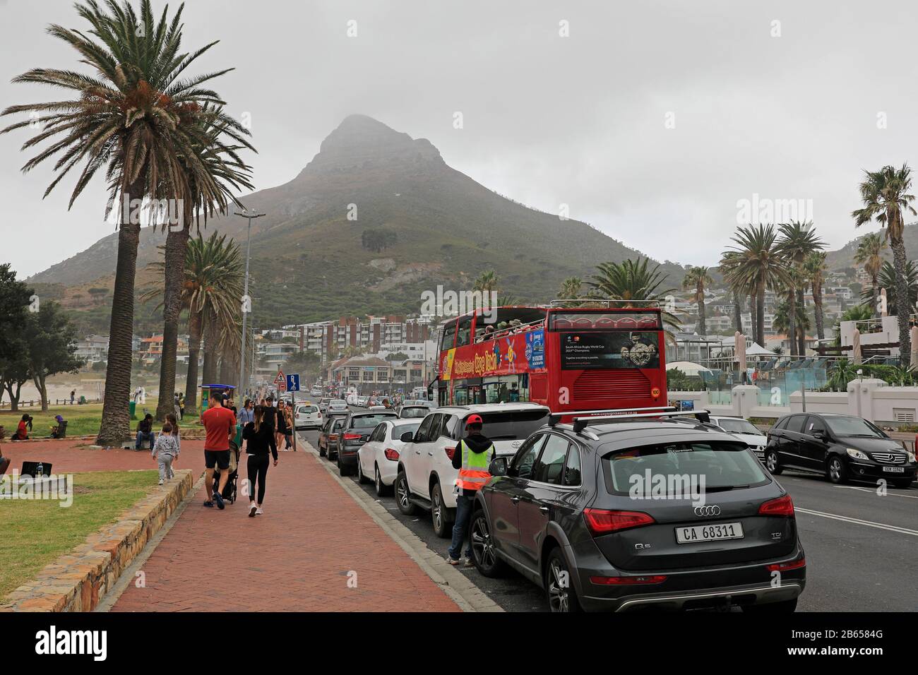 Bus touristique rouge à Victoria Road Camps Bay, Cape Town, Afrique du Sud. Banque D'Images