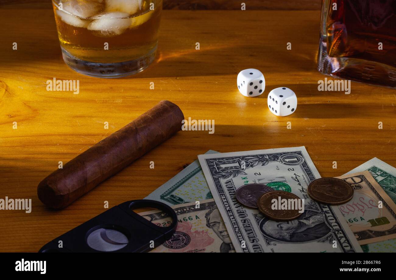 Jeu - tabac Cigar, dés blancs, whisky écossais et billets en dollars américains sur la table en bois Banque D'Images