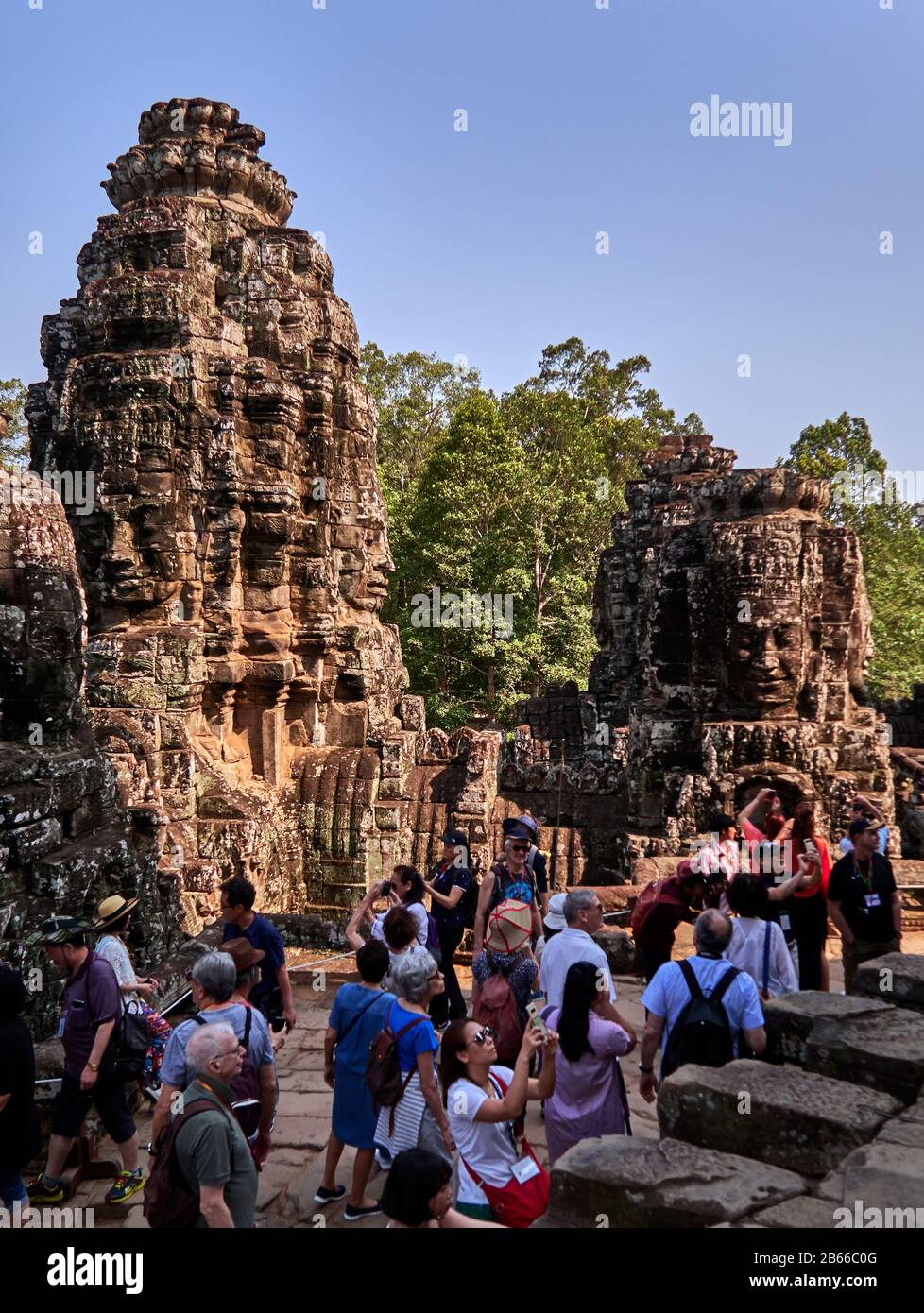 Grès rose, le magnifique temple Bayon situé dans la dernière capitale de l'Empire khmer - Angkor Thom. Ses 54 tours gothiques sont décorées avec 216 visages souriants énormes. Construit à la fin du XIIe siècle ou au début du XIIIe siècle comme temple officiel de l'État du roi Jayavarman VII Banque D'Images