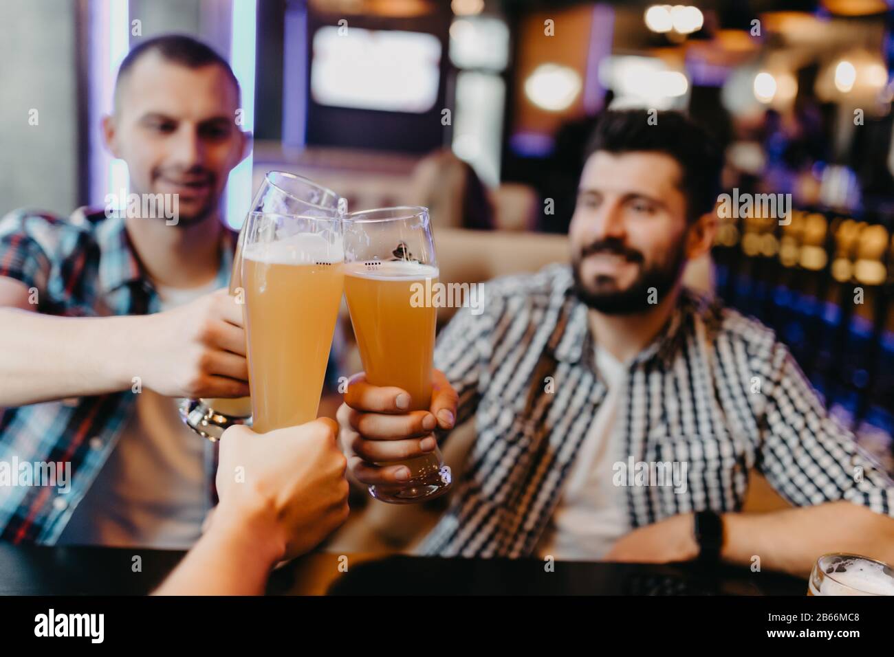 Les gens, les hommes, les loisirs, l'amitié et de fête concept - heureux amis boire une bière et clinking glasses au bar ou au pub Banque D'Images