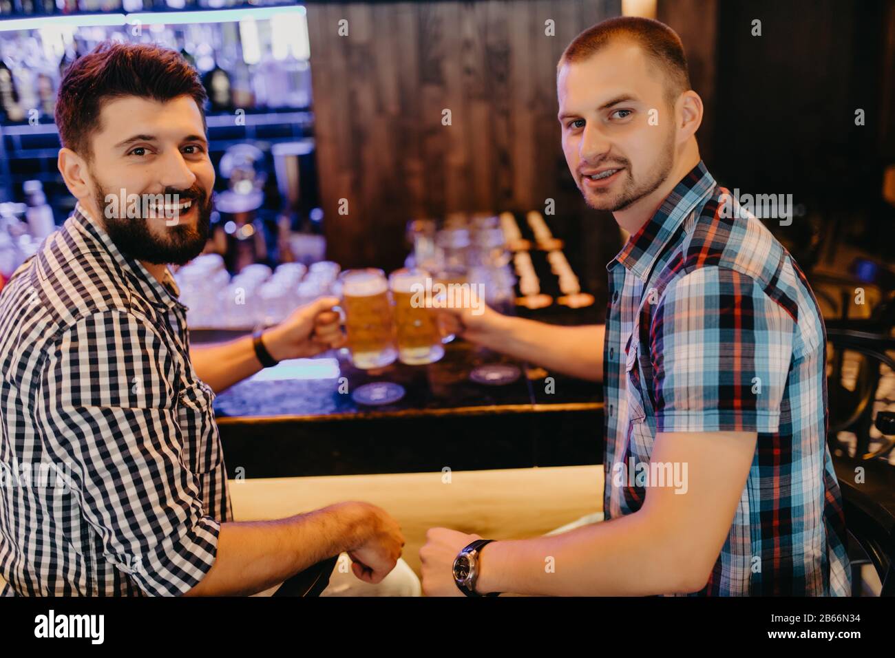 Deux beaux amis dans un pub avec des verres de bière. Banque D'Images