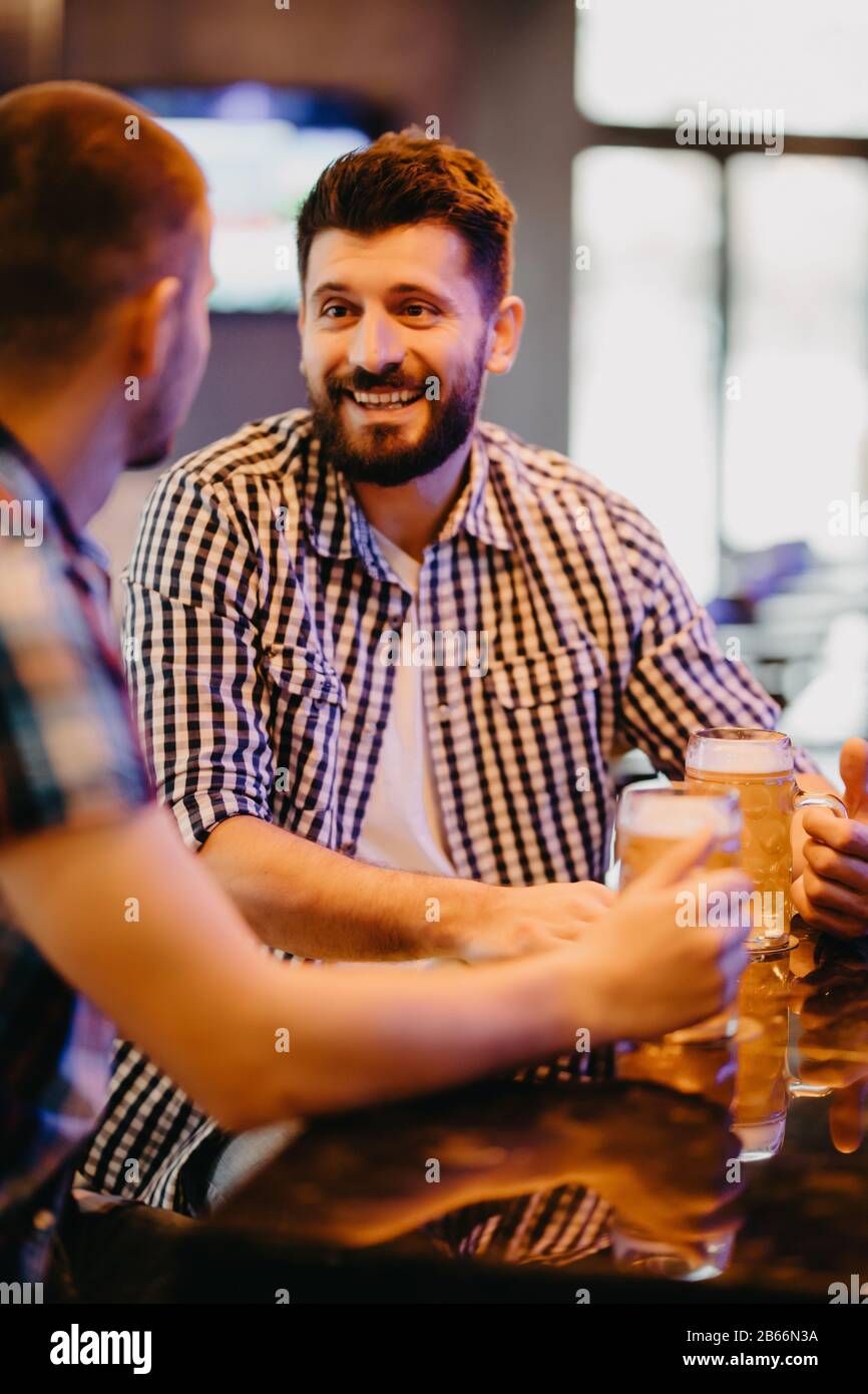 Deux beaux amis dans un pub avec des verres de bière. Banque D'Images