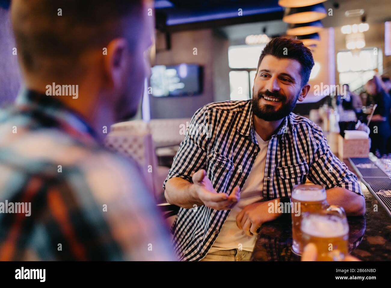 Deux beaux amis dans un pub avec des verres de bière. Banque D'Images