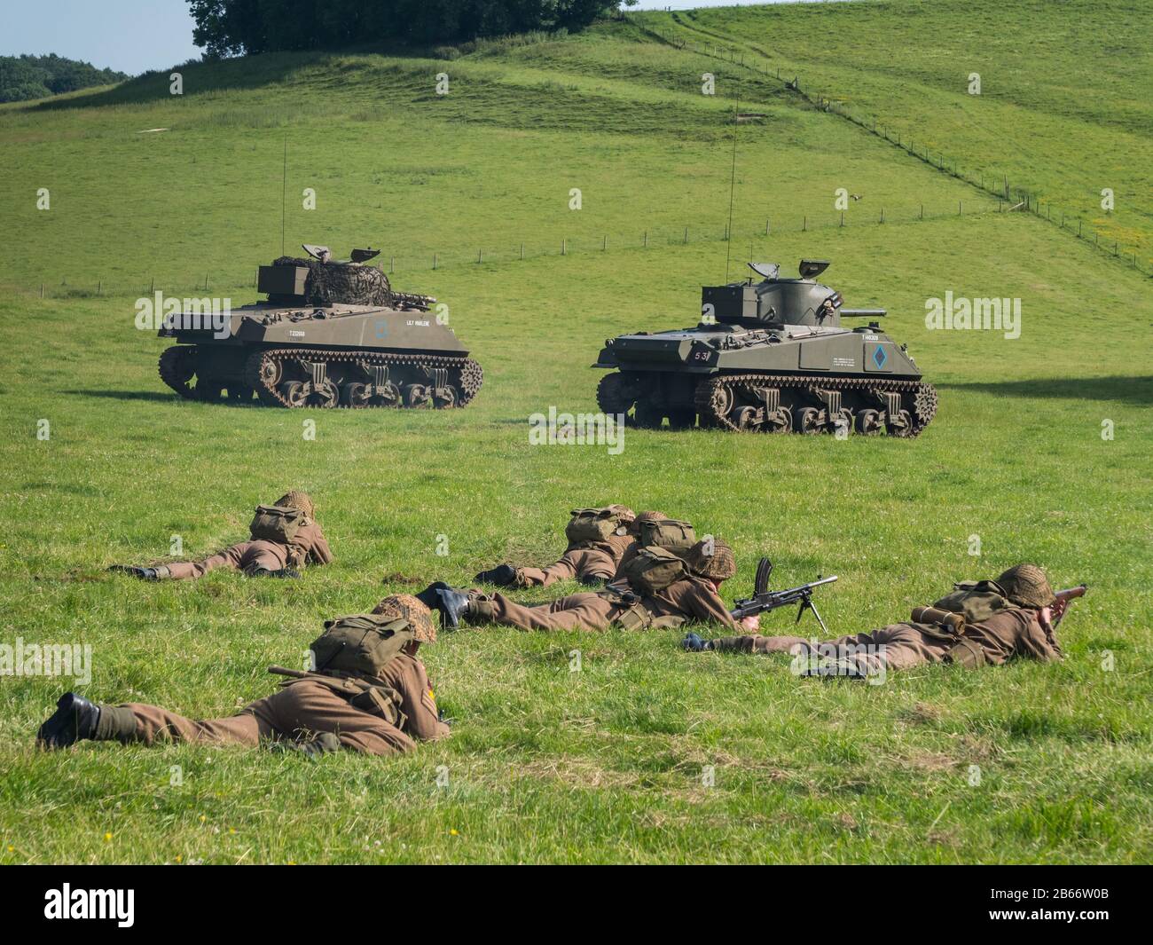 Les soldats actuels du Royal Anglian Regiment dans le kit de la deuxième Guerre mondiale exécutant une attaque de peloton d'infanterie réédiction avec le soutien de chars Sherman. Banque D'Images