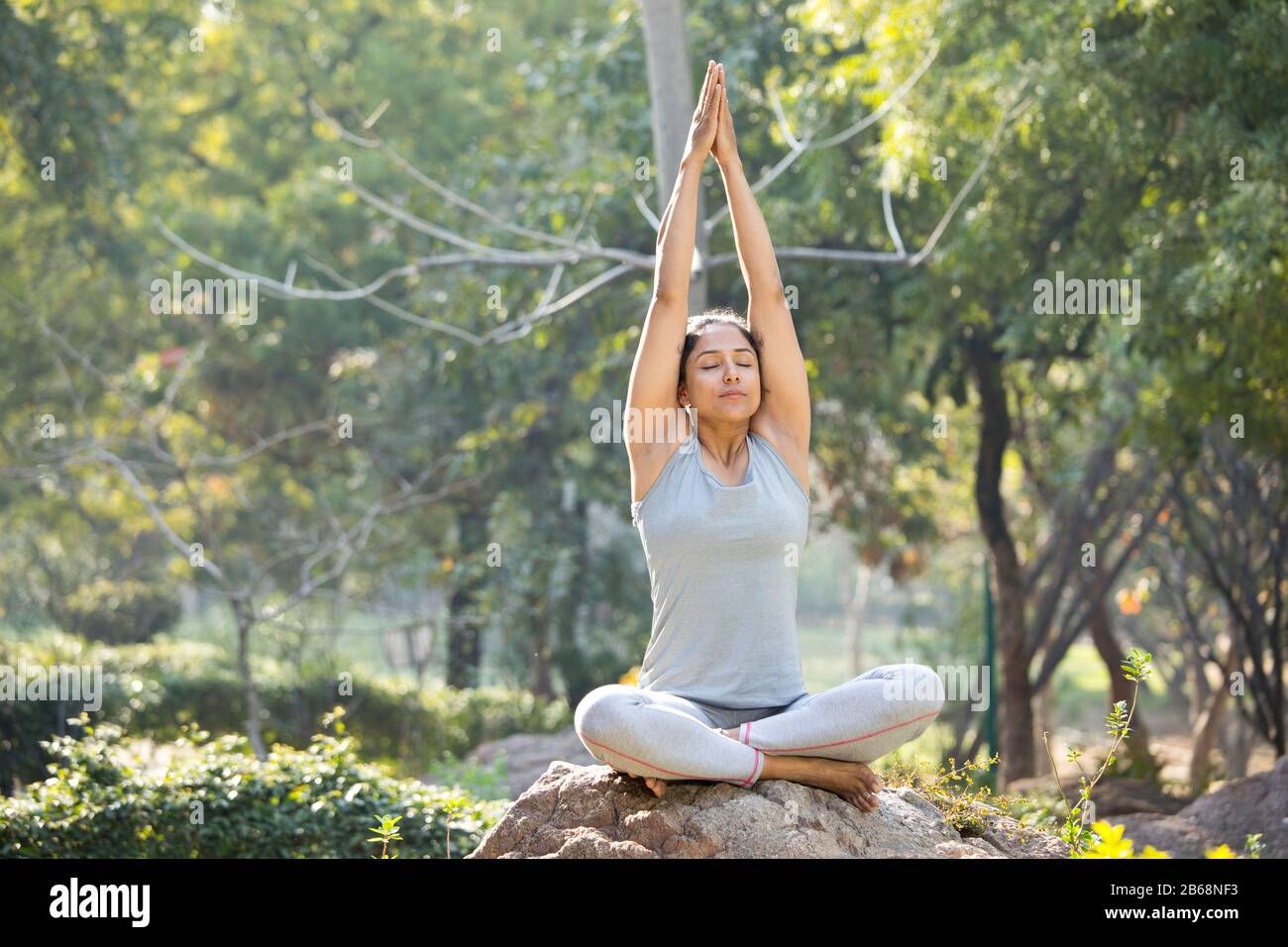 Femme dans les vêtements de sport pratiquant le yoga arbre pose au parc Banque D'Images