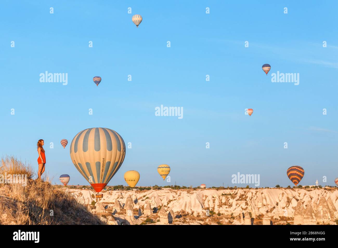 Foules de touristes regardant un ballon en montgolfière survolant le paysage rocheux de Cappadoce Turquie, depuis le point d'observation Banque D'Images