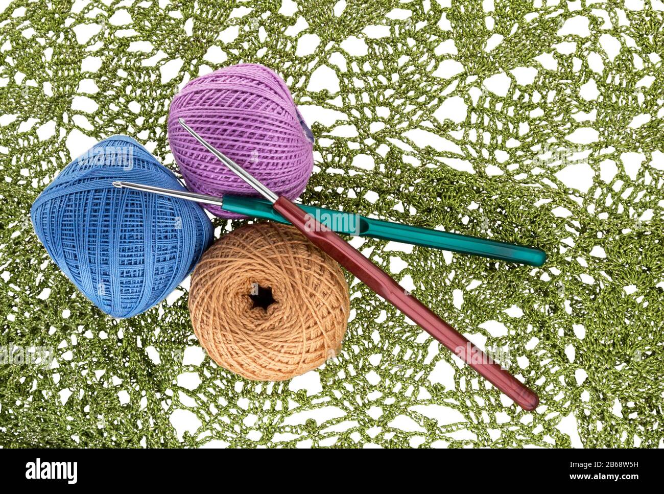 Motif en crochet, boule de fil de laine et crochet en crochet isolé sur blanc. Banque D'Images