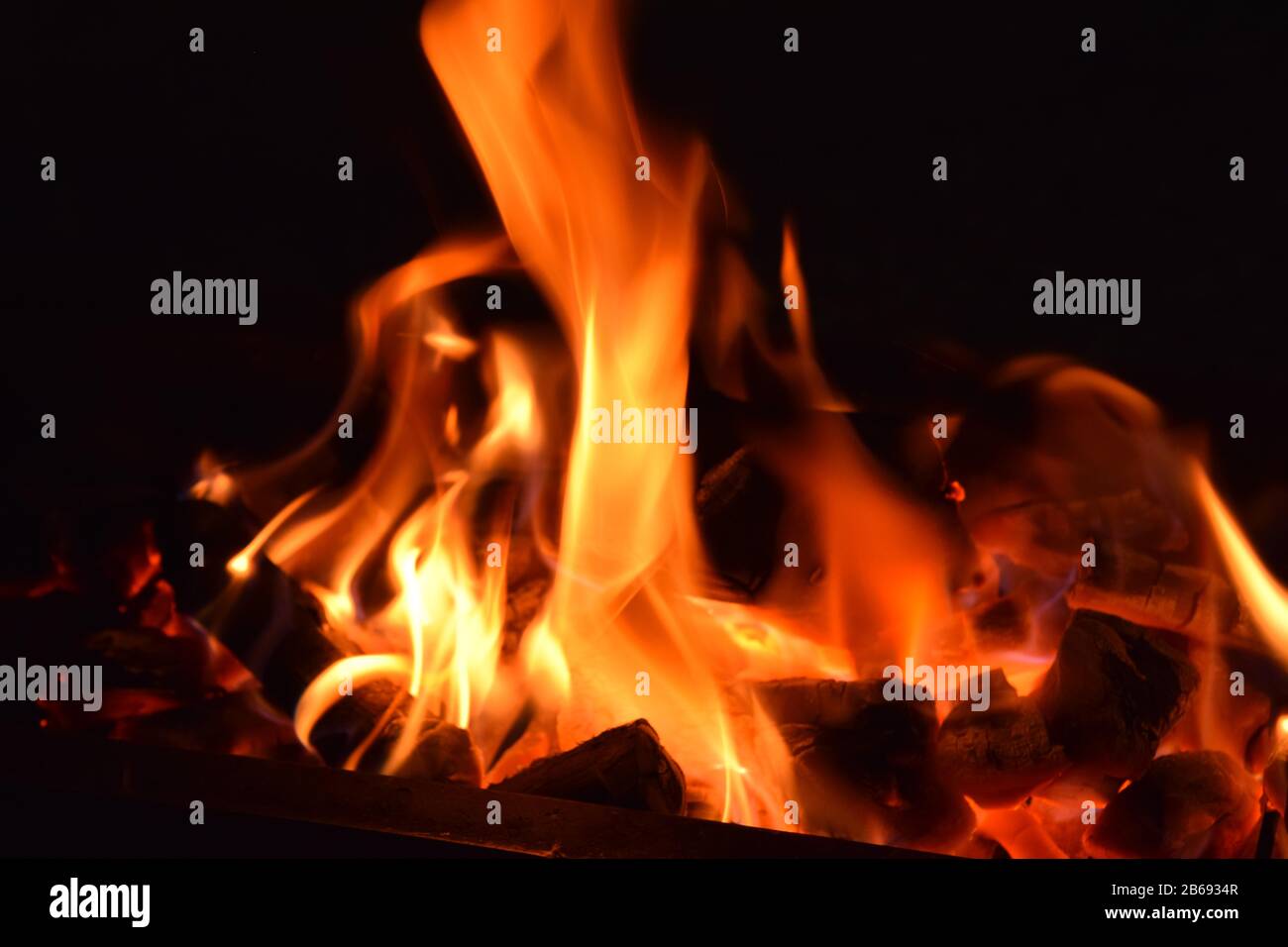 Combustion de charbon avec flamme rouge avec fond noir Banque D'Images