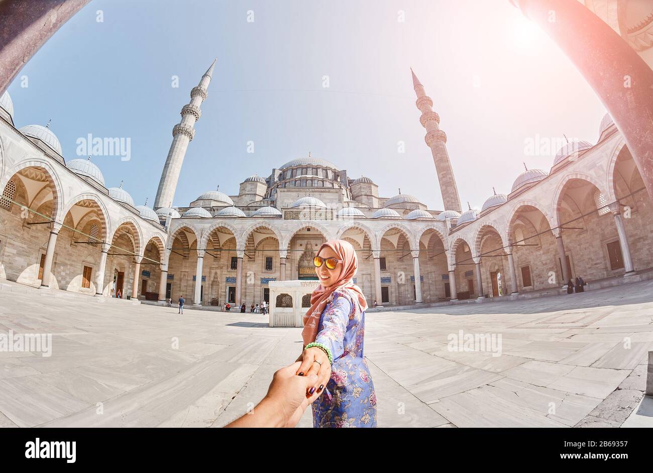 Suivez-moi. Une femme musulmane dans un foulard conduit son ami à la mosquée turque Suleymaniye, voyage et concept de religion. Banque D'Images
