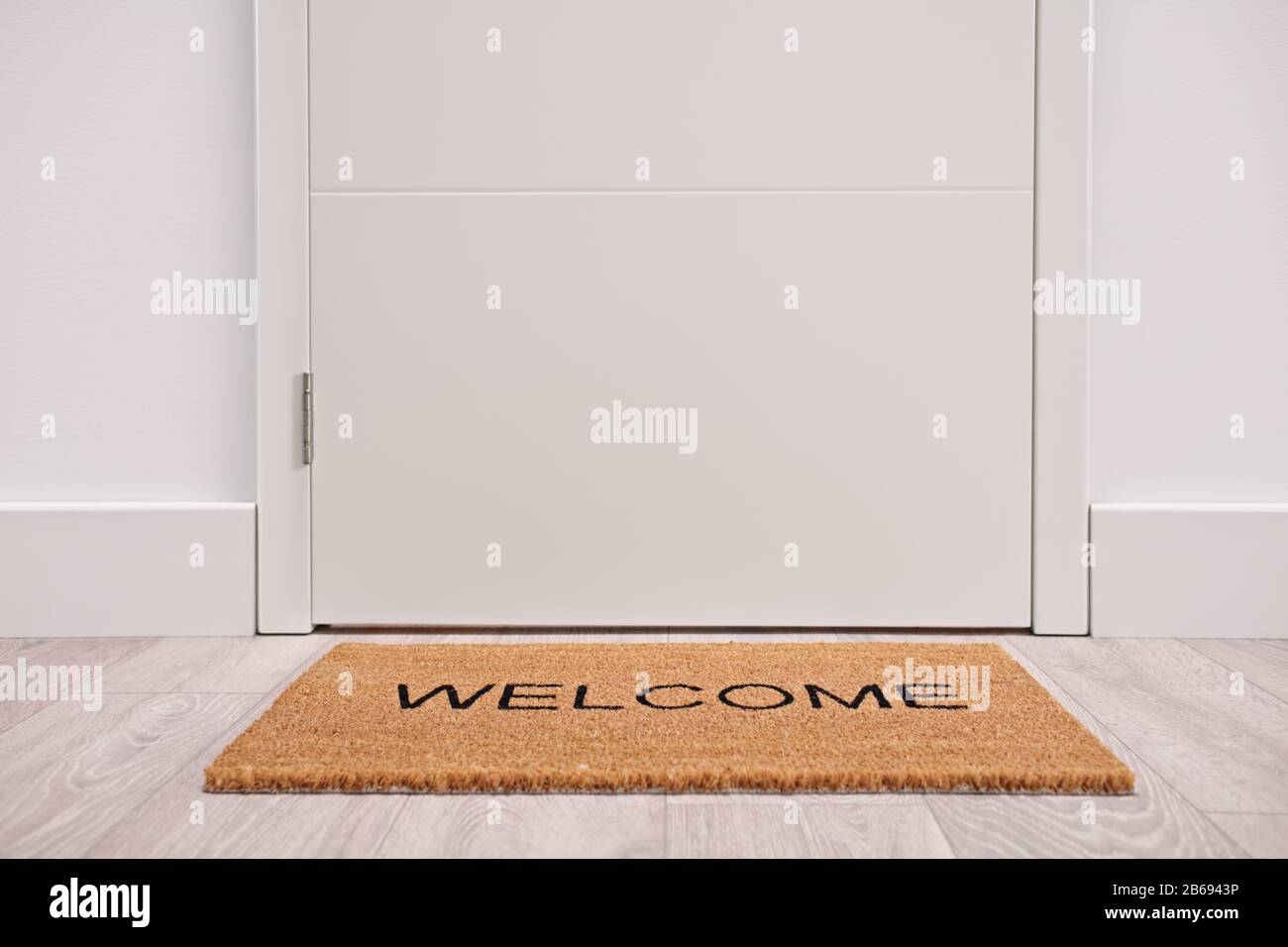Porte blanche avec tapis de bienvenue Banque D'Images