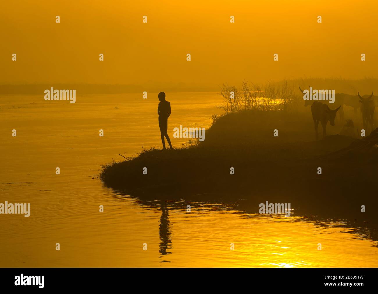 Enfant de la tribu Mundari sur la rive du Nil au coucher du soleil, Equatoria central, Terekeka, Soudan du Sud Banque D'Images