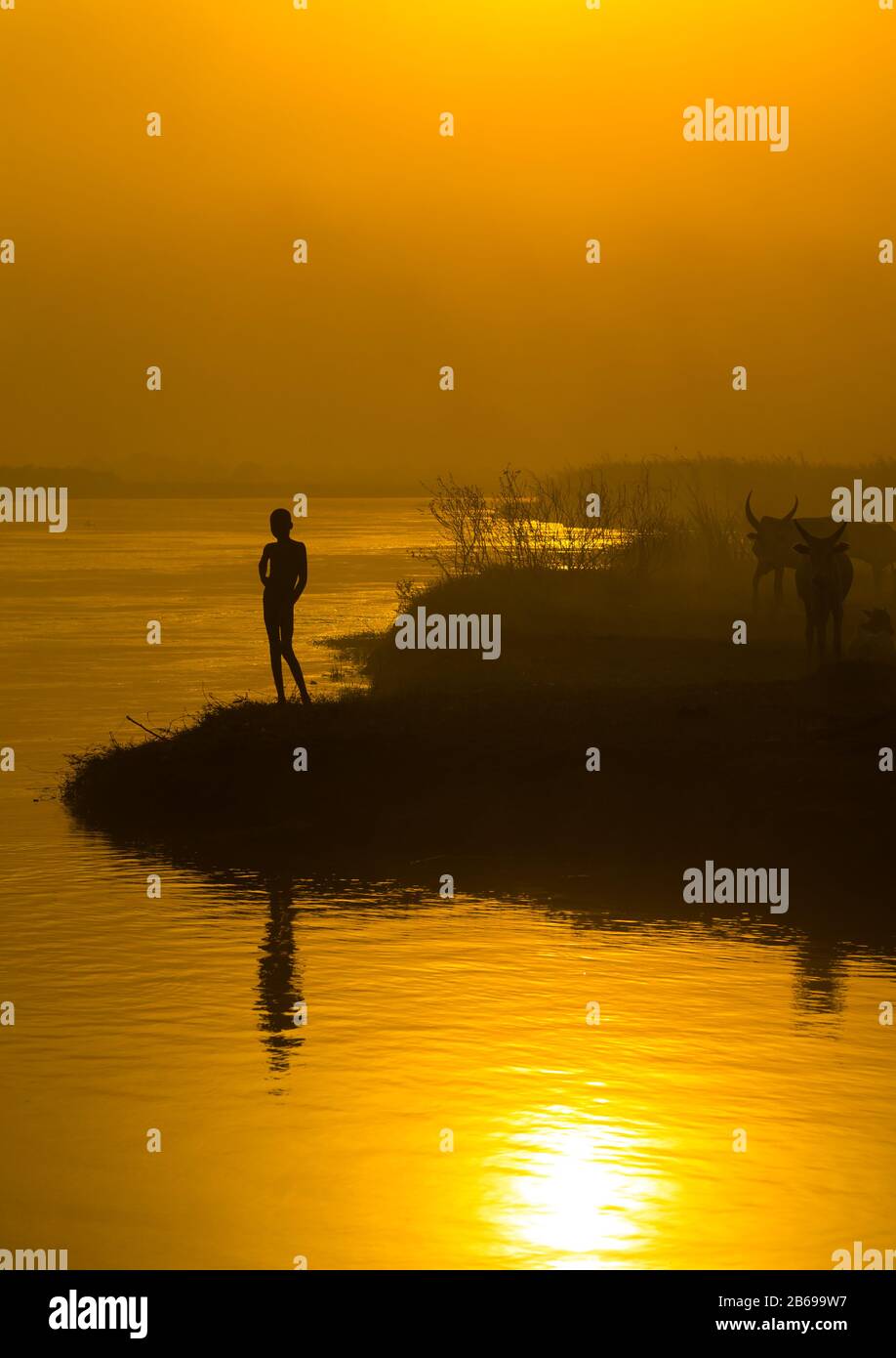 Enfant de la tribu Mundari sur la rive du Nil au coucher du soleil, Equatoria central, Terekeka, Soudan du Sud Banque D'Images