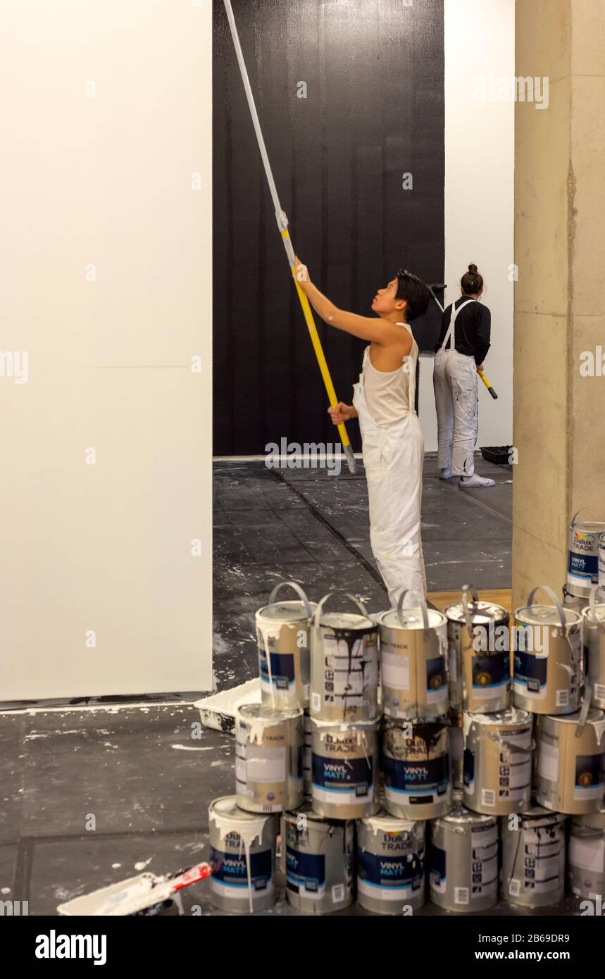 Des artistes masculins et féminins peignent des murs en noir et blanc dans le cadre d'une installation d'œuvres d'art live appelée A Life ( Black and White) par l'artiste bulgare Nedko Solakov à Tate Modern London, Royaume-Uni à partir de 2020 Banque D'Images