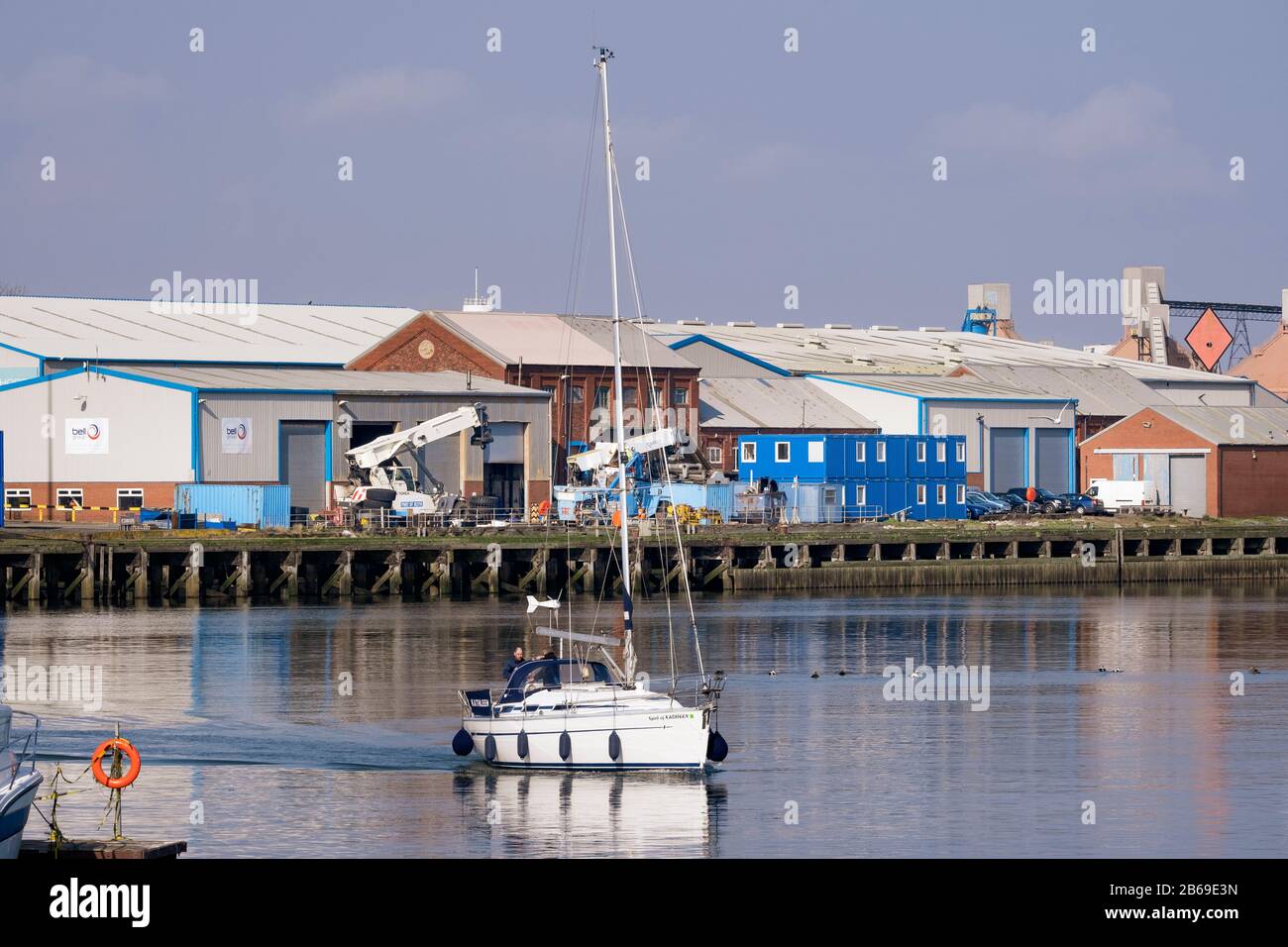 Bateau à voile traversant les entrepôts du port de Blyth sur la côte de Northumberland Banque D'Images