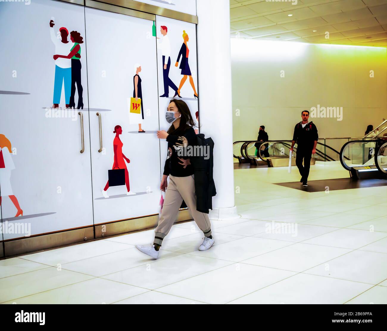 Une femme porte un masque chirurgical dans le Westfield Mall de New York le jeudi 5 mars 2020. En raison des préoccupations concernant la propagation du coronavirus, les gens achètent des masques de visage bien que le CDC indique que de bonnes techniques de lavage des mains sont plus efficaces pour prévenir la propagation du virus. (© Richard B. Levine) Banque D'Images