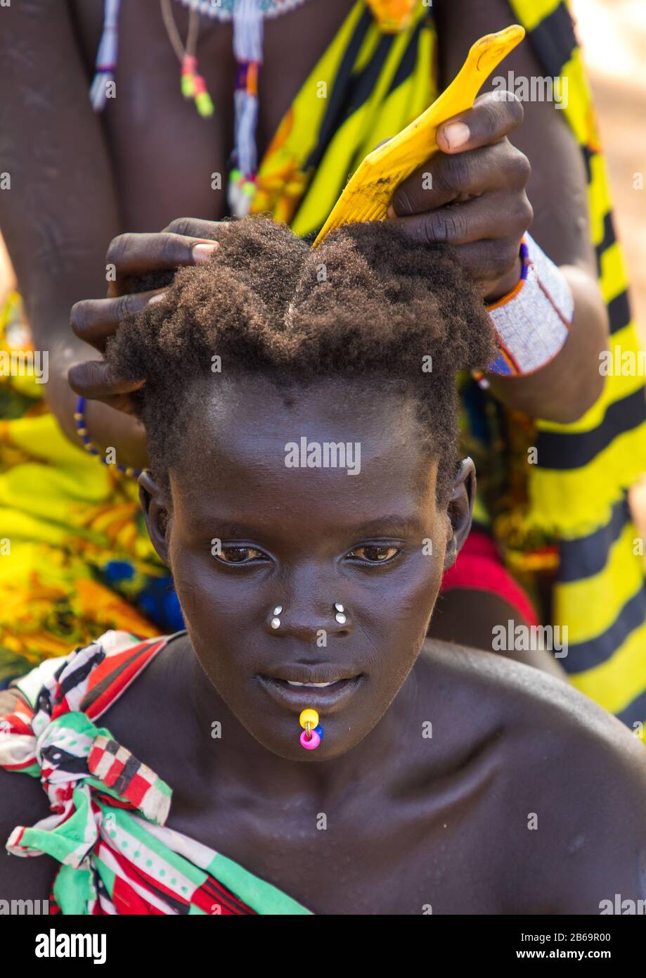 Femme de la tribu Larim qui fait du braid à un ami, Boya Mountains, Imatong, Soudan du Sud Banque D'Images