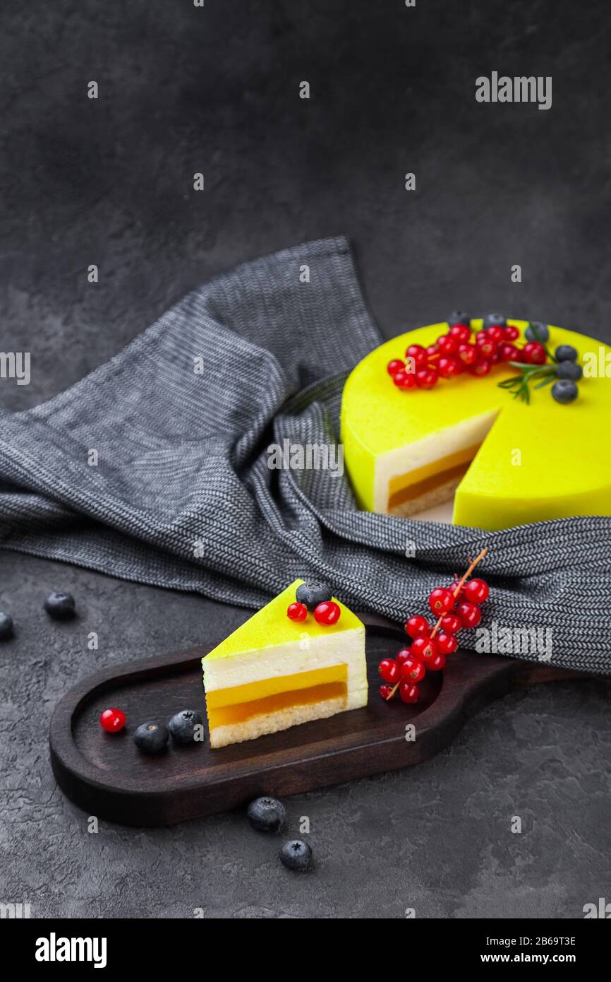 Gateau Jaune A La Couche De Citron Et Piece Sur Plaque En Bois Et Cassis Rouge Decore De Bleuets Sur Fond Sombre Espace De Copie Place Pour Le Texte Ve Photo Stock