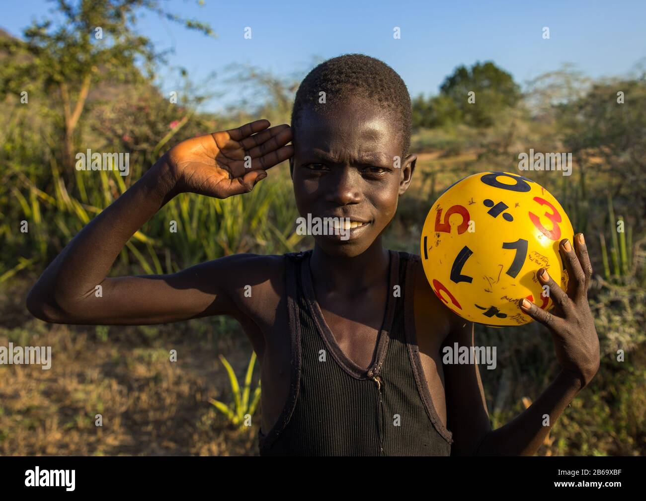 Portrait d'un garçon de tribu Larim saluant avec la main, les monts Boya, Imatong, Soudan du Sud Banque D'Images