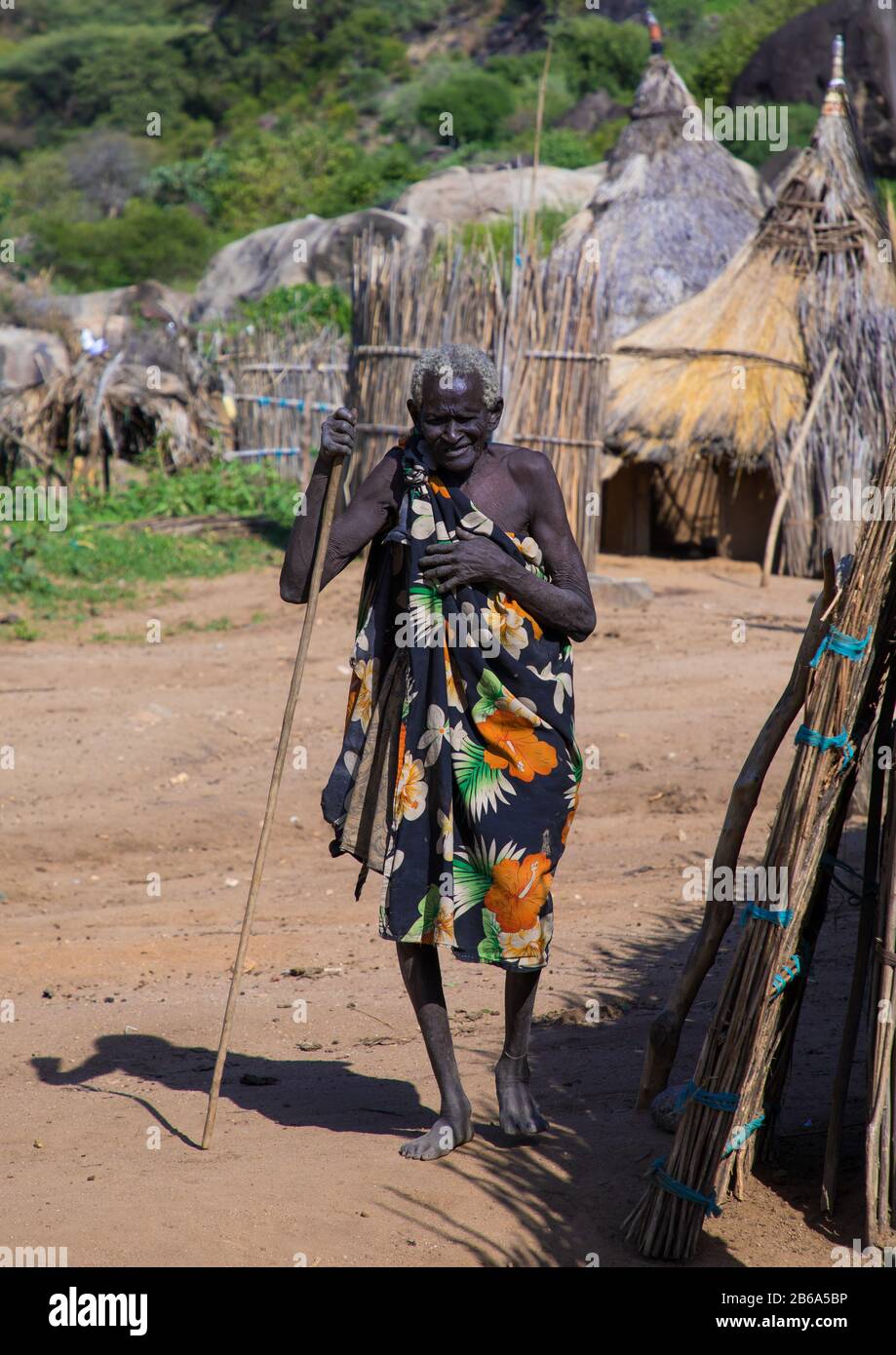 Vieille femme passant dans un village traditionnel de tribu Larim, les monts Boya, Imatong, Soudan du Sud Banque D'Images