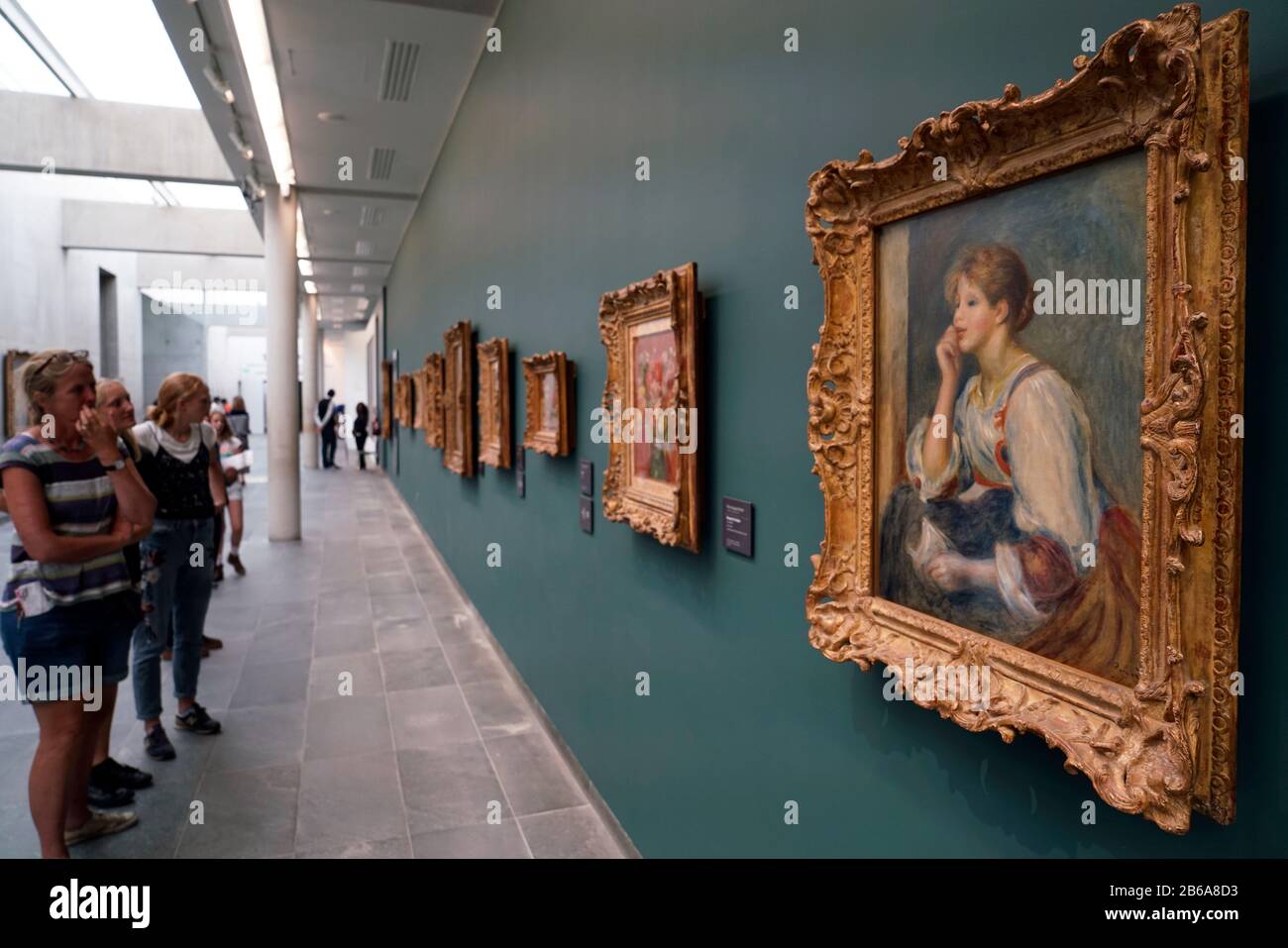 Les visiteurs qui apprécient la peinture de Renoir 'femme al la lettre' sont exposés au Musée l'Orangerie, Paris France Banque D'Images