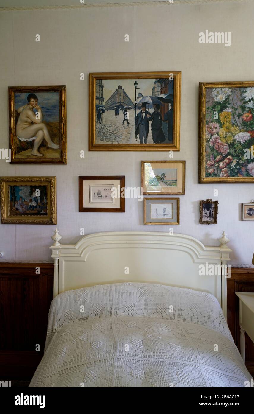 Le lit et les peintures sur le mur dans la chambre. Claude Monet Maison et jardin.Giverny.région de Normandie.France Banque D'Images