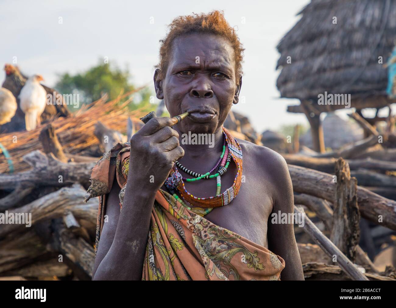 Femme de la tribu Toposa, âgée de deux ans, fume dans un village, État de Namorunyang, Kapoeta, Soudan du Sud Banque D'Images