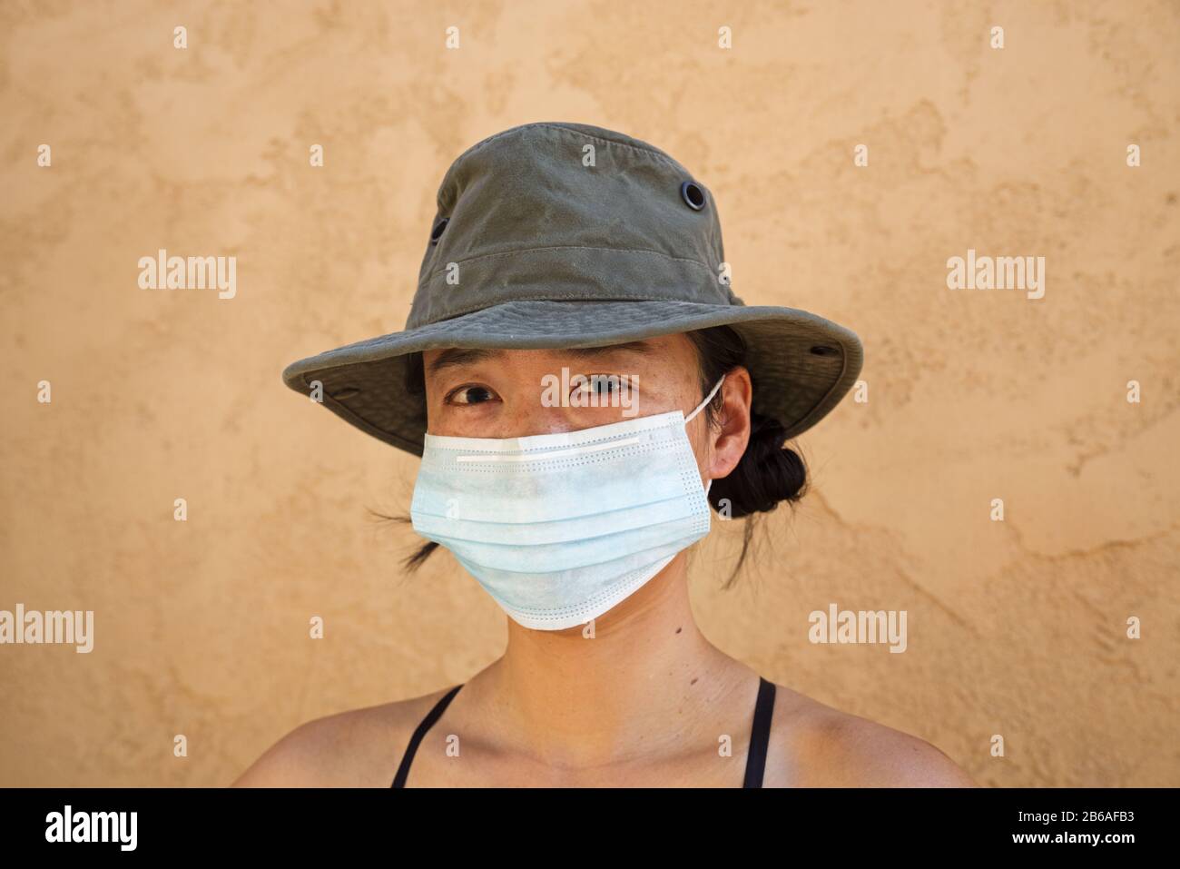 Femme asiatique portant un masque et un chapeau Banque D'Images