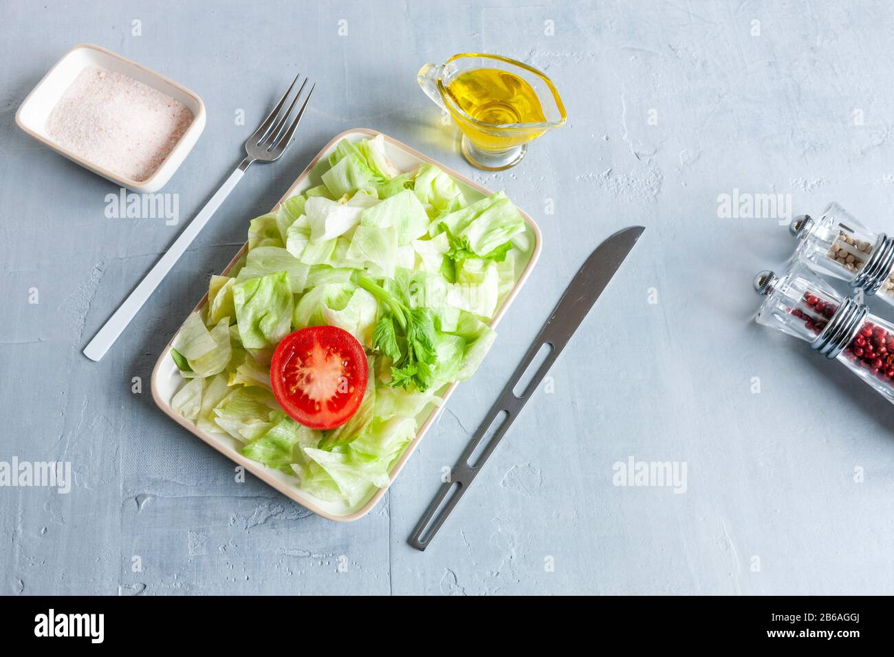 Assiette avec laitue iceberg verte, huile d'olive, tomatoe, concept intermittent de jeûne, régime alimentaire, perte de poids Banque D'Images