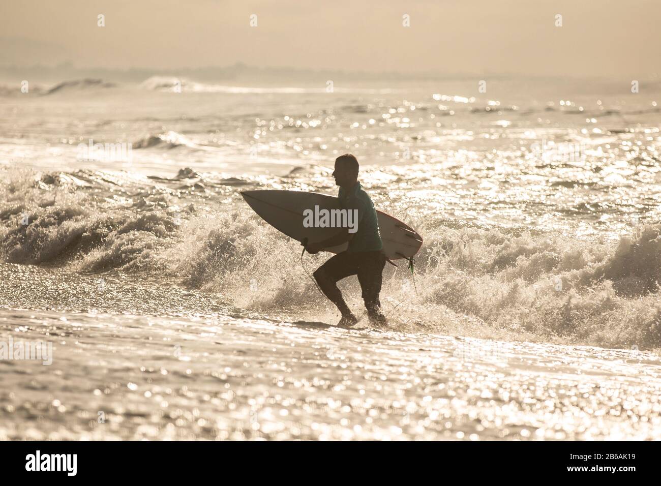 Surfeur sortant de l'océan après la séance du matin. Banque D'Images