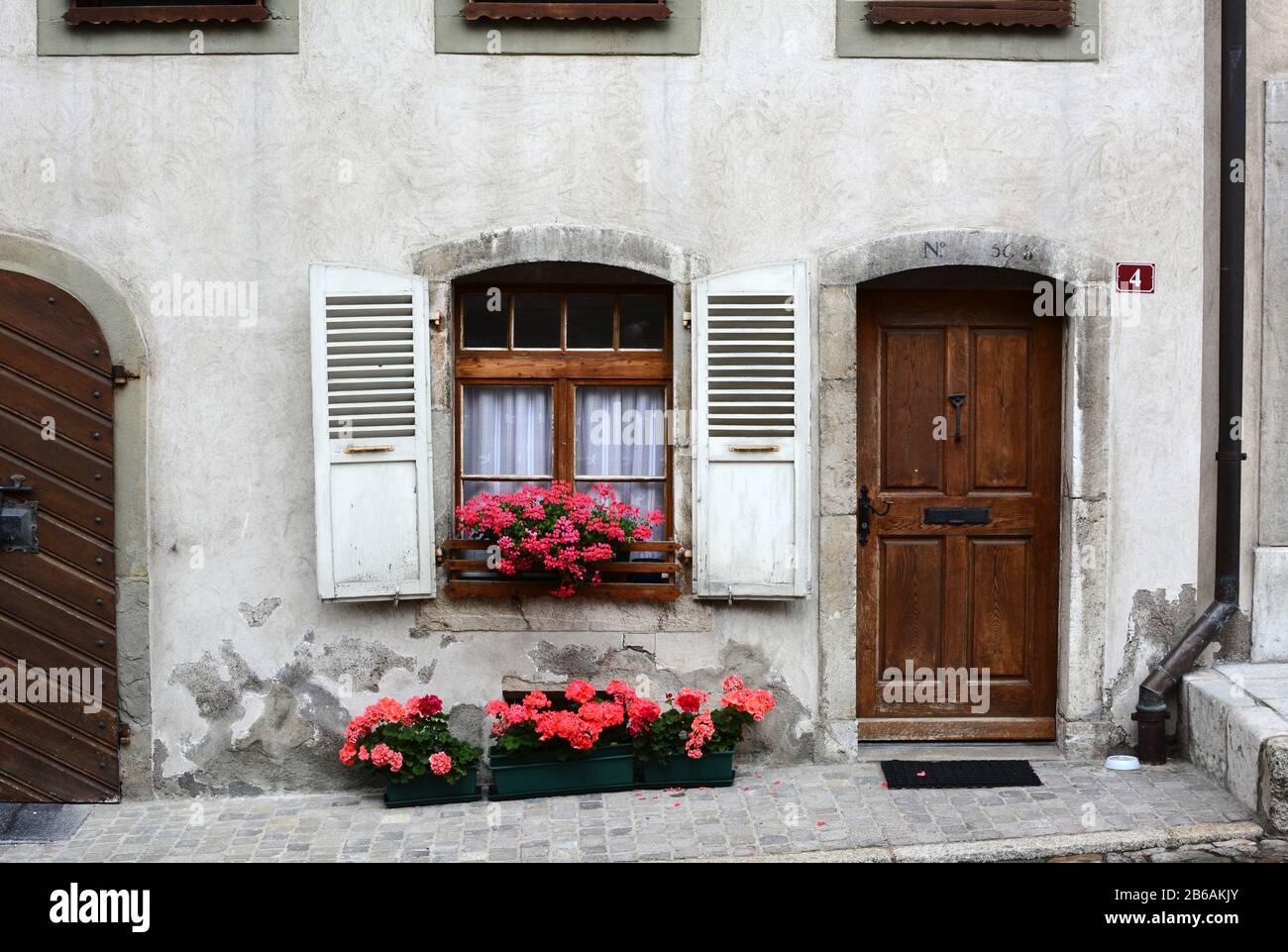 Gruyères, SUISSE - 8 JUILLET 2014 : porte d'entrée sur la maison suisse traditionnelle. La maison pittoresque se trouve dans la rue principale pavée de la vieille ville de Gruyer Banque D'Images