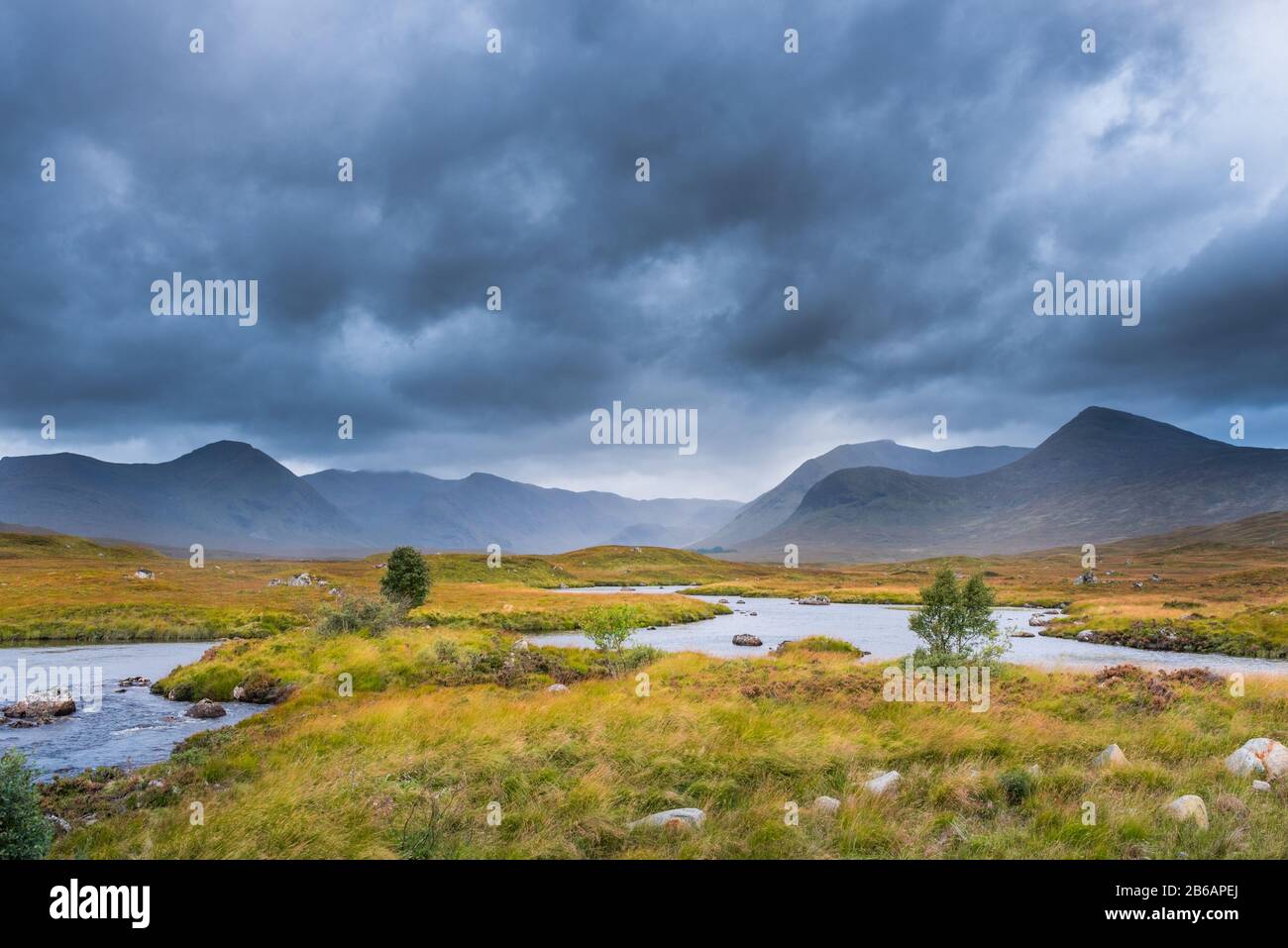 Collines sous un ciel orageux avec un ruisseau sinueux au premier plan. Scottish Highlands, Royaume-Uni Banque D'Images