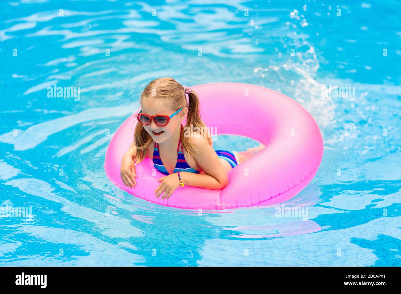 Enfant Dans Une Piscine Flottante Sur Toy Anneau Enfants Se Baignent Arc En Ciel Colores Float Pour De Jeunes Enfants Petite Fille S Amusant Sur La Famille Vacances D Ete En Tro Photo Stock Alamy