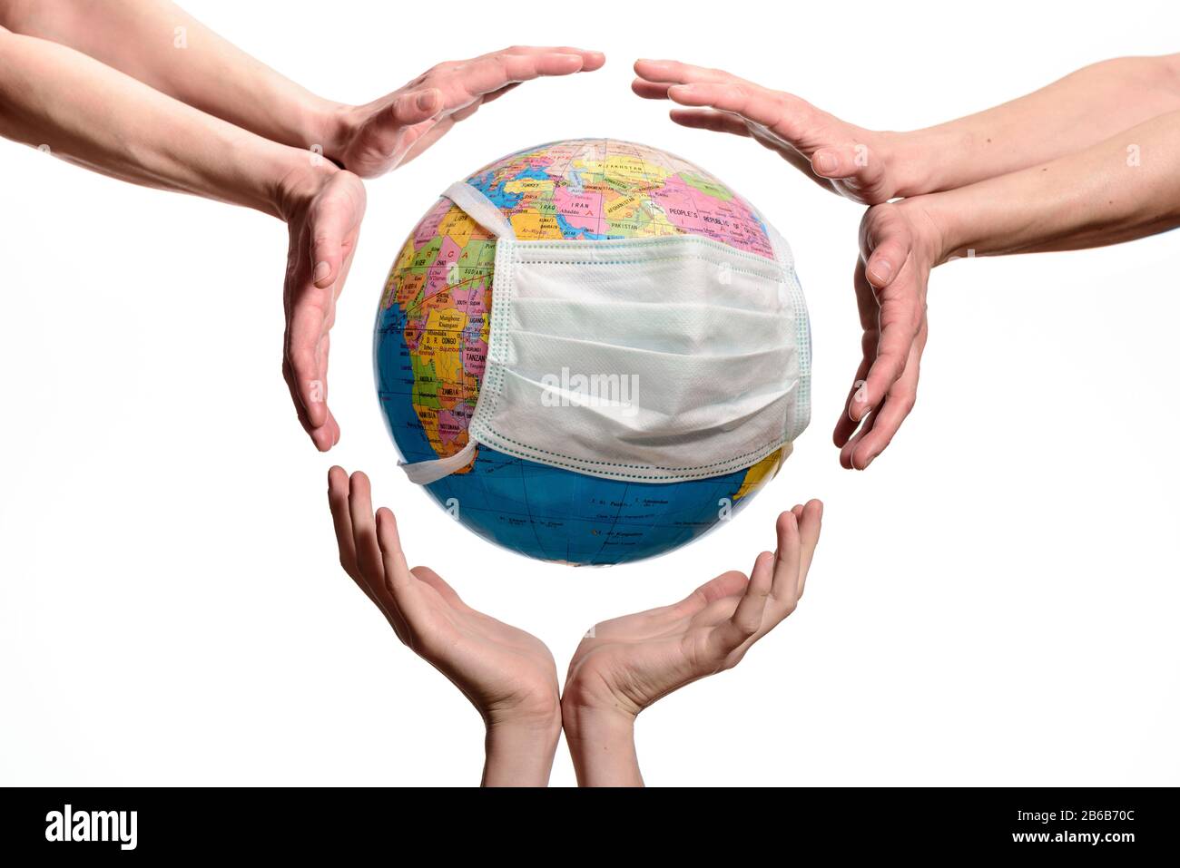Sauver Le Monde Du Coronavirus. Mains autour du globe terrestre avec un masque de protection , sauver ou protéger la planète, isolée sur fond blanc. Banque D'Images