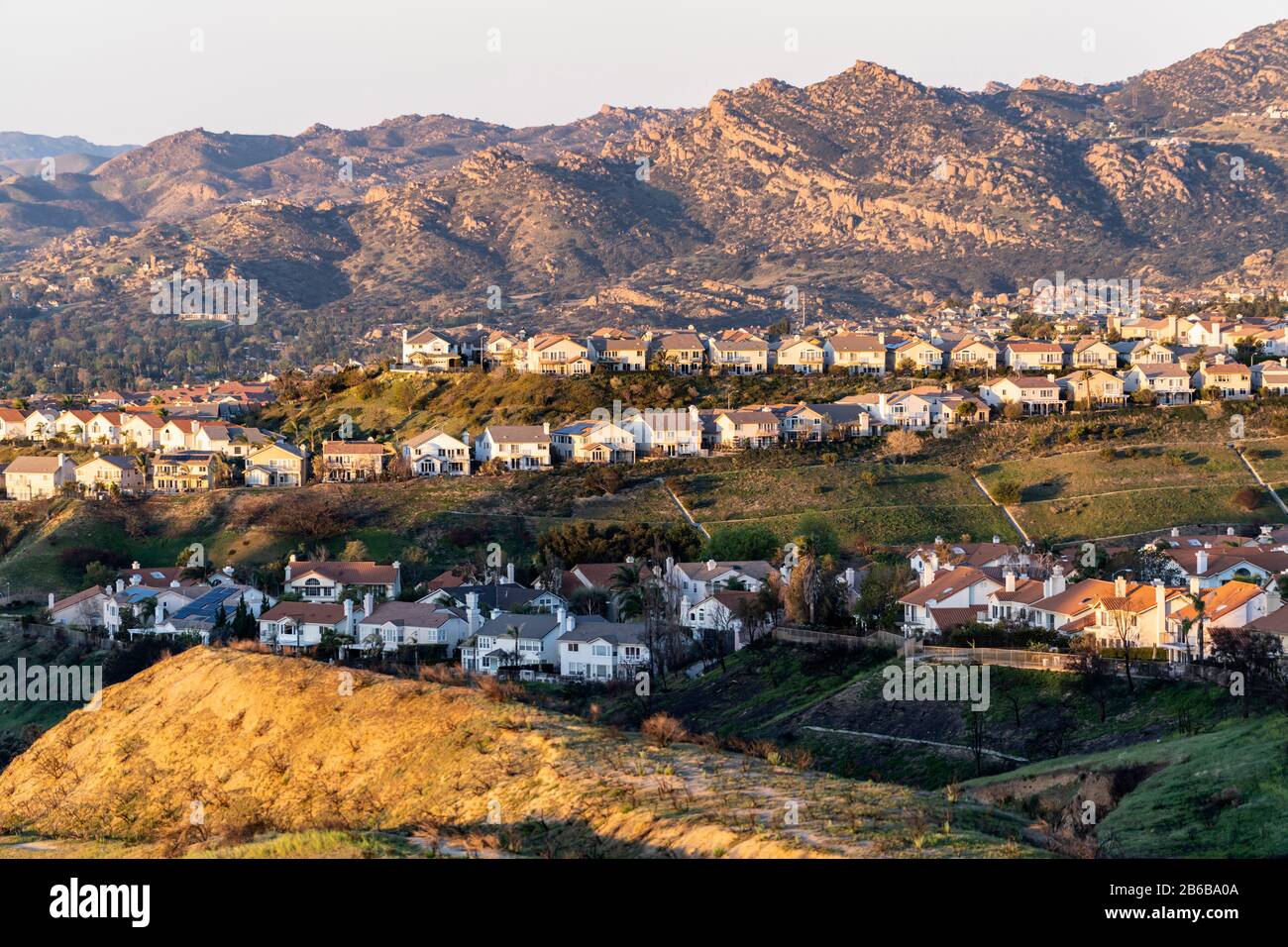 Rangées de maisons perchées surplombant la vallée de San Fernando dans le nord de Los Angeles, Californie. Les montagnes de Santa Susana sont en arrière-plan. Banque D'Images
