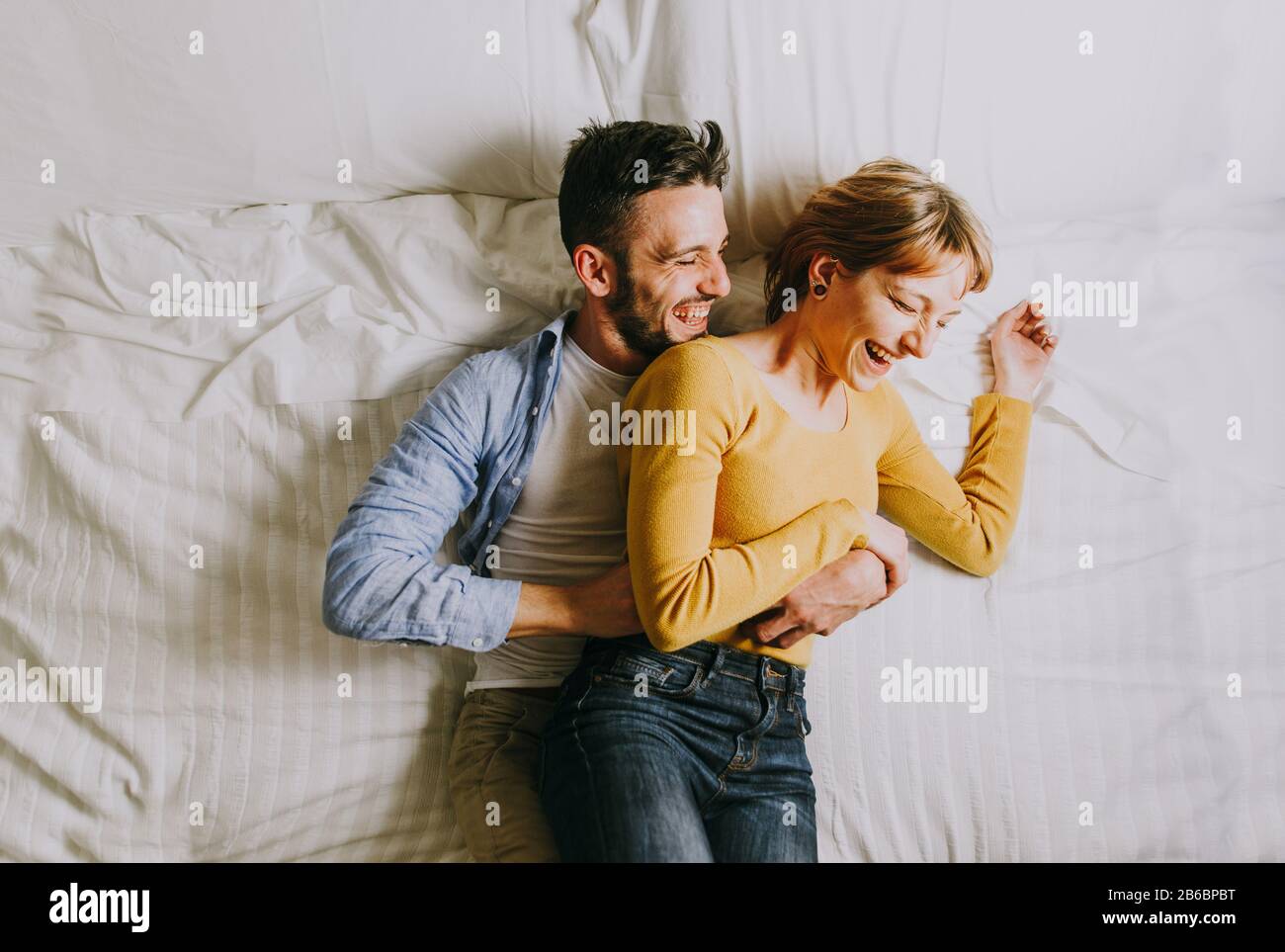 Deux jeunes adultes à la maison - Beau couple heureux d'amoureux s'amuser dans  le lit Photo Stock - Alamy