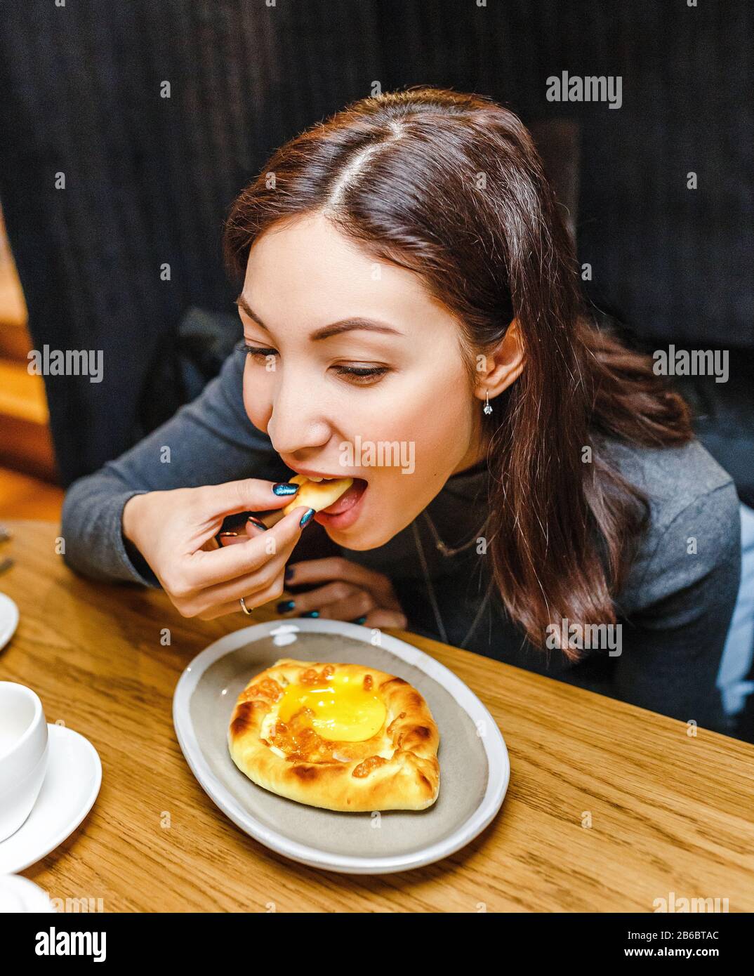 Femme mangeant Khachapuri traditionnel dans le restaurant géorgien, cuisine locale et délicieux concept de voyage de nourriture Banque D'Images