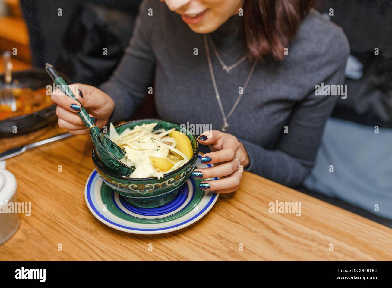 Femme mangeant une soupe de cuisine locale traditionnelle asiatique au restaurant Banque D'Images