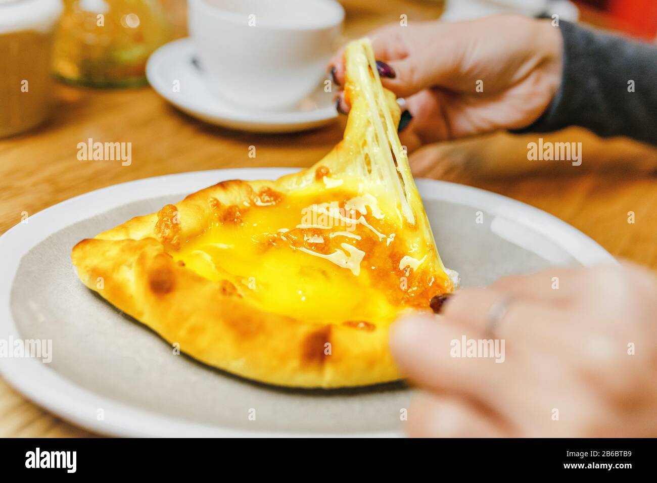 Femme mangeant Khachapuri traditionnel dans le restaurant géorgien, cuisine locale et délicieux concept de voyage de nourriture Banque D'Images