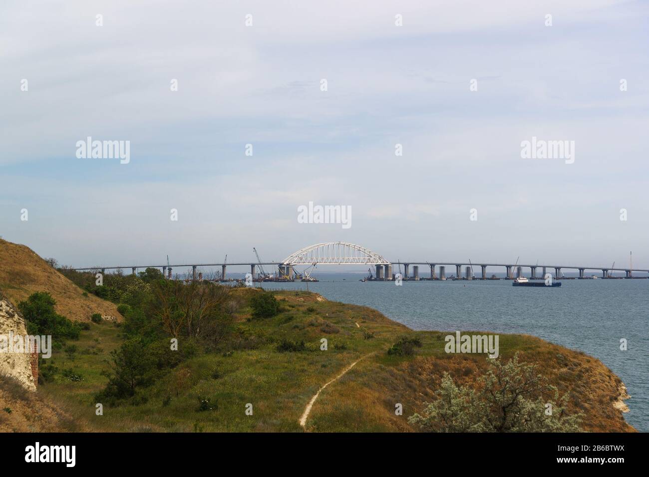 Portée de voûte du pont de Crimée sur le fairway pour le passage des navires. Vue de la ville de Kerch. Jour de printemps nuageux Banque D'Images
