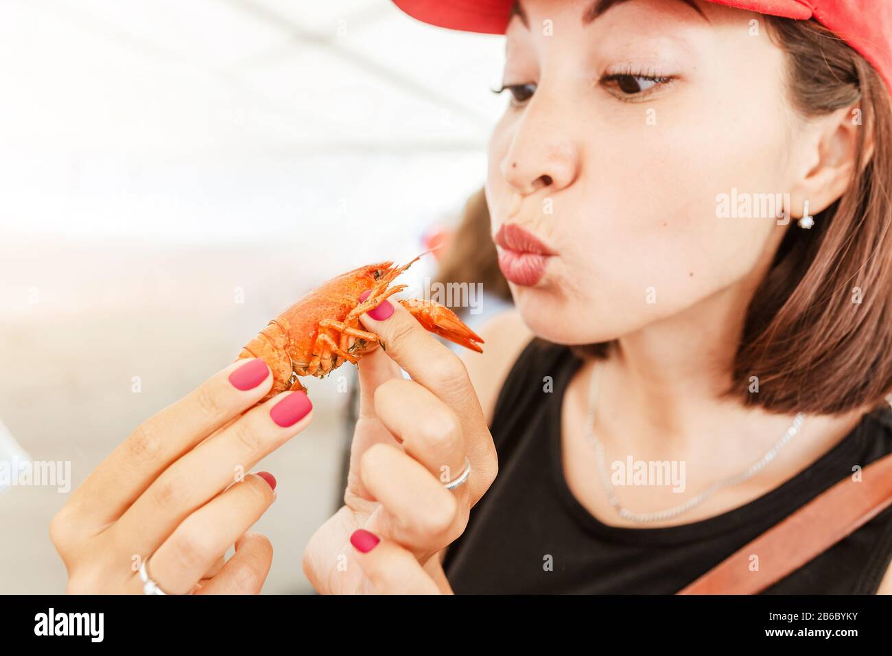 Jeune femme mangeant de délicieux écrevisses bouillies rouges ou du homard de la rivière à ramper. Cuisine locale et concept de fruits de mer Banque D'Images