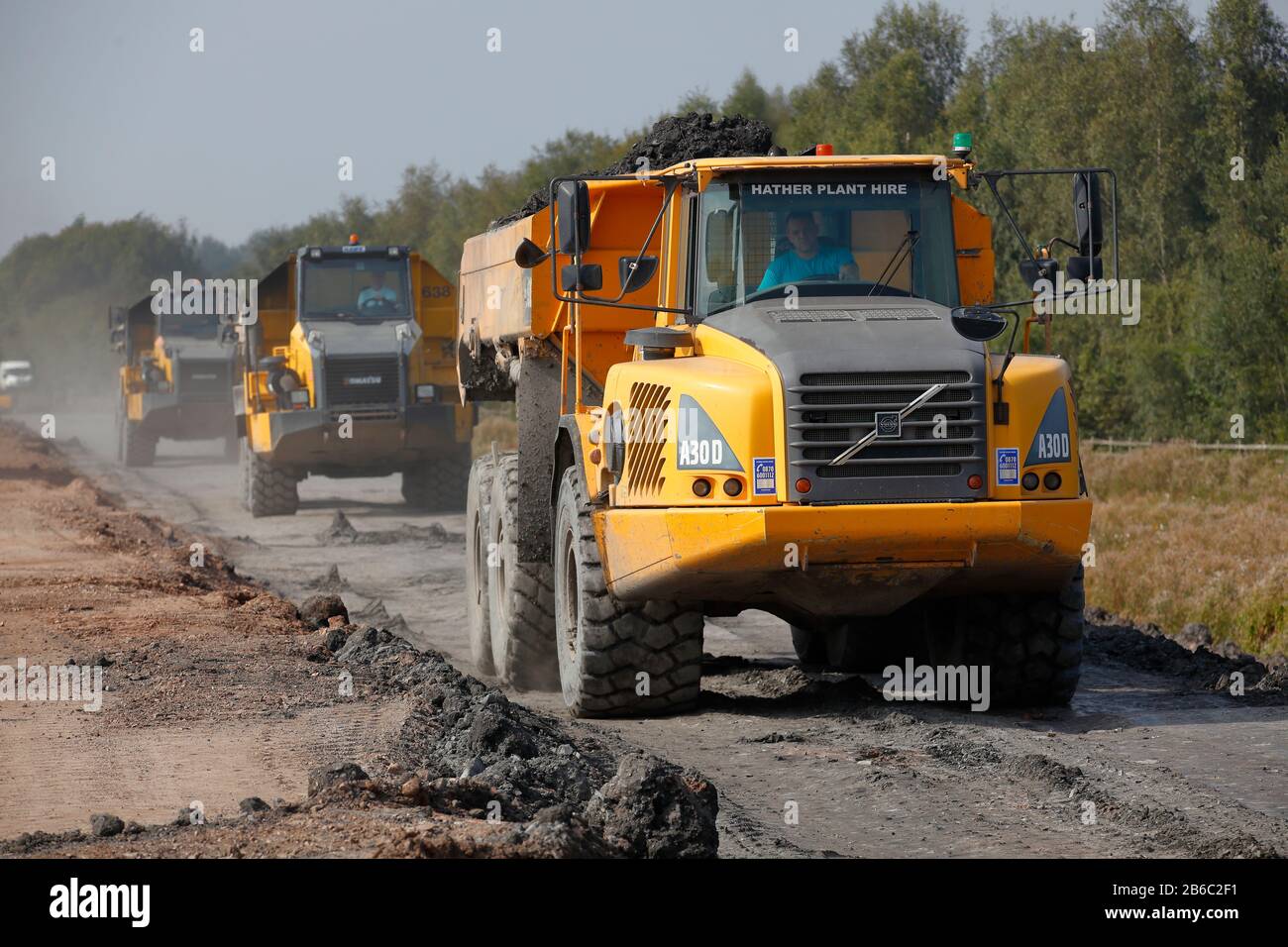 Les camions à benne basculante Komatsu et Volvo transportent le matériel de remblayage le long d'une route de transport sur une nouvelle construction de route à Doncaster, connue sous le nom de Great Yorkshire Way Banque D'Images