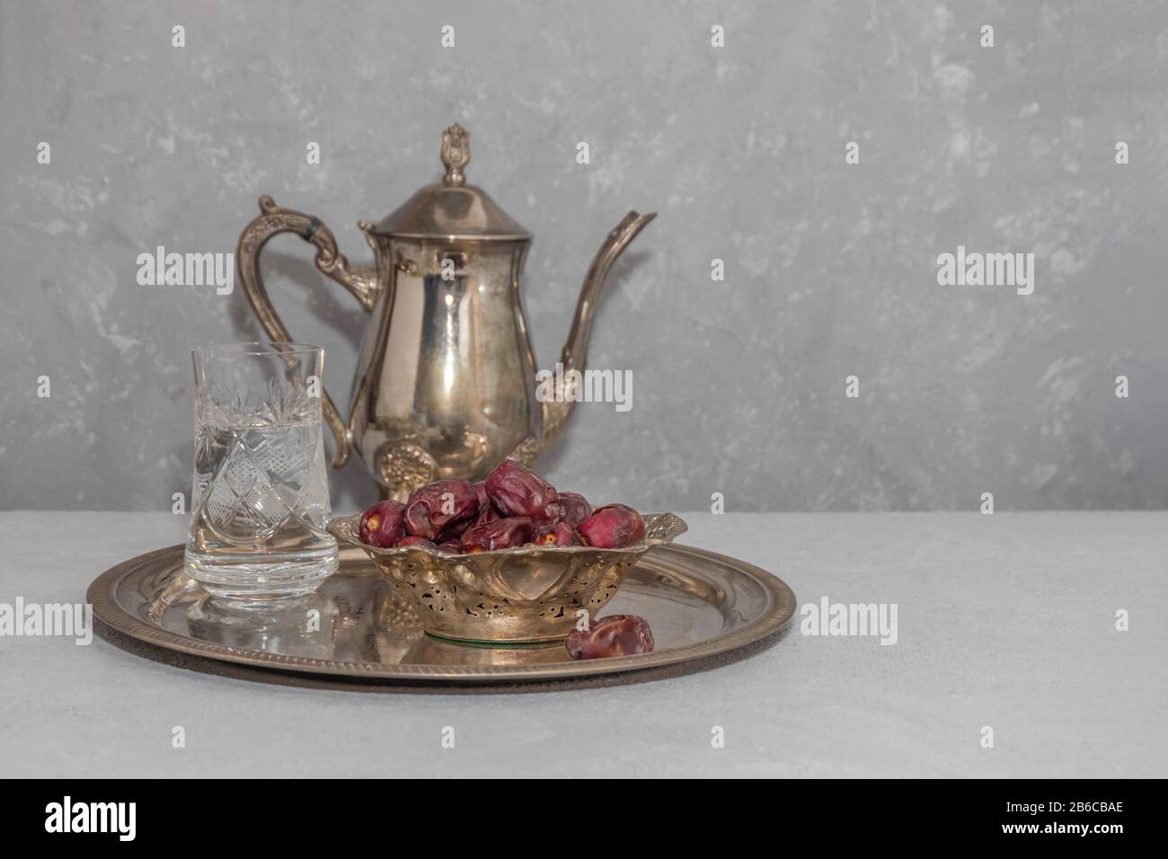 Concept de jeûne du Ramadan. Dates d'eau et de séchage sur plateau vintage sur fond neutre avec espace de copie Banque D'Images