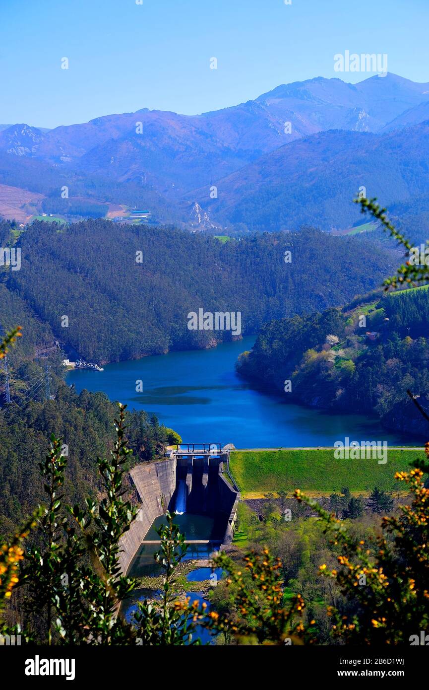 Réservoir avec barrage de centrale hydroélectrique au milieu de la forêt et à côté des montagnes. Banque D'Images